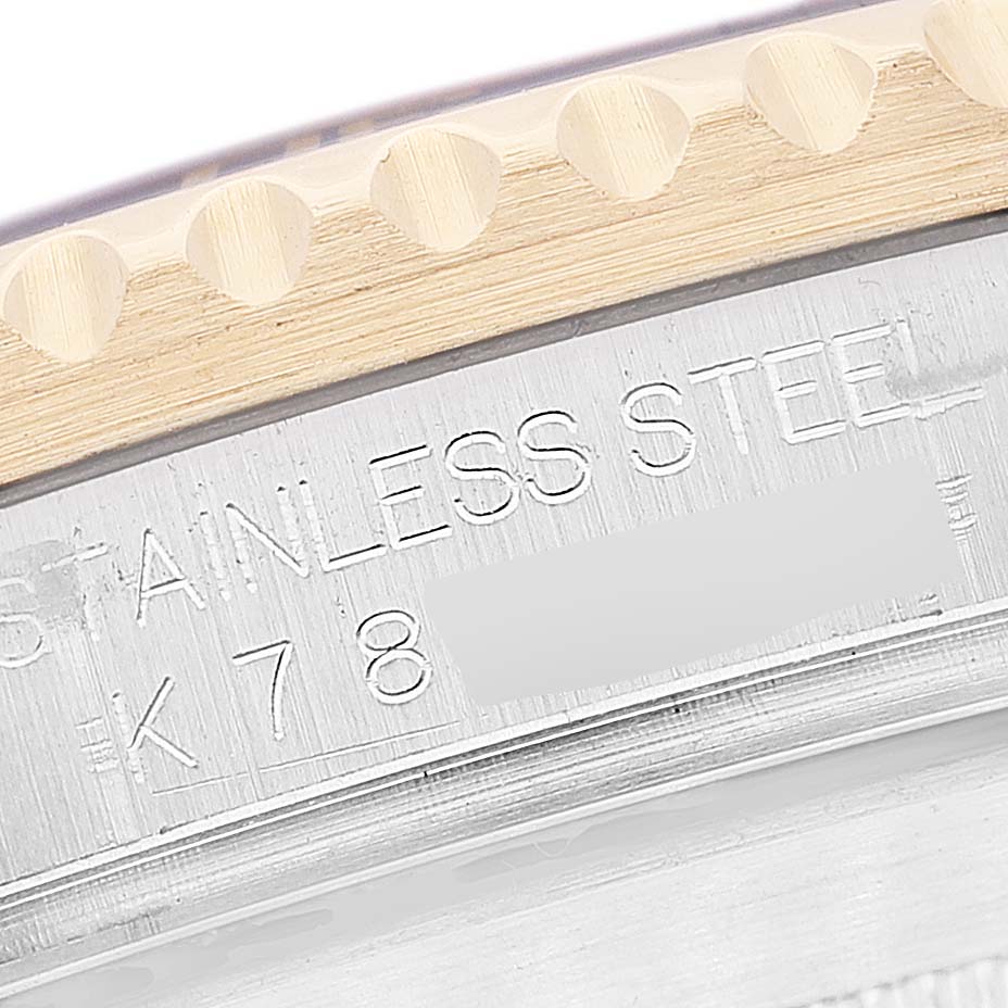 This close-up image shows the engraved text and part of the bezel of a Rolex Submariner 16613 Men's Steel and Gold (two tone) Champagne Dial 16613 Men's Steel and Gold (two tone) Champagne Dial watch.