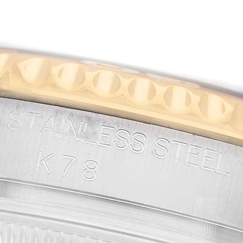 The image shows a close-up of the Yacht-Master Rolex's case edge, focusing on the stainless steel with engraved text.