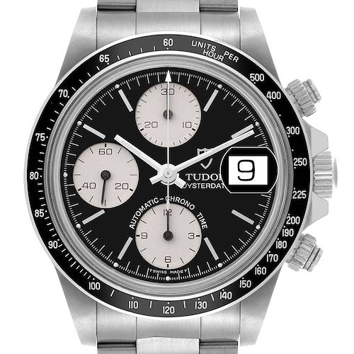 The Tudor Big Block watch is shown from a front angle, displaying the dial, subdials, bezel, and date window.