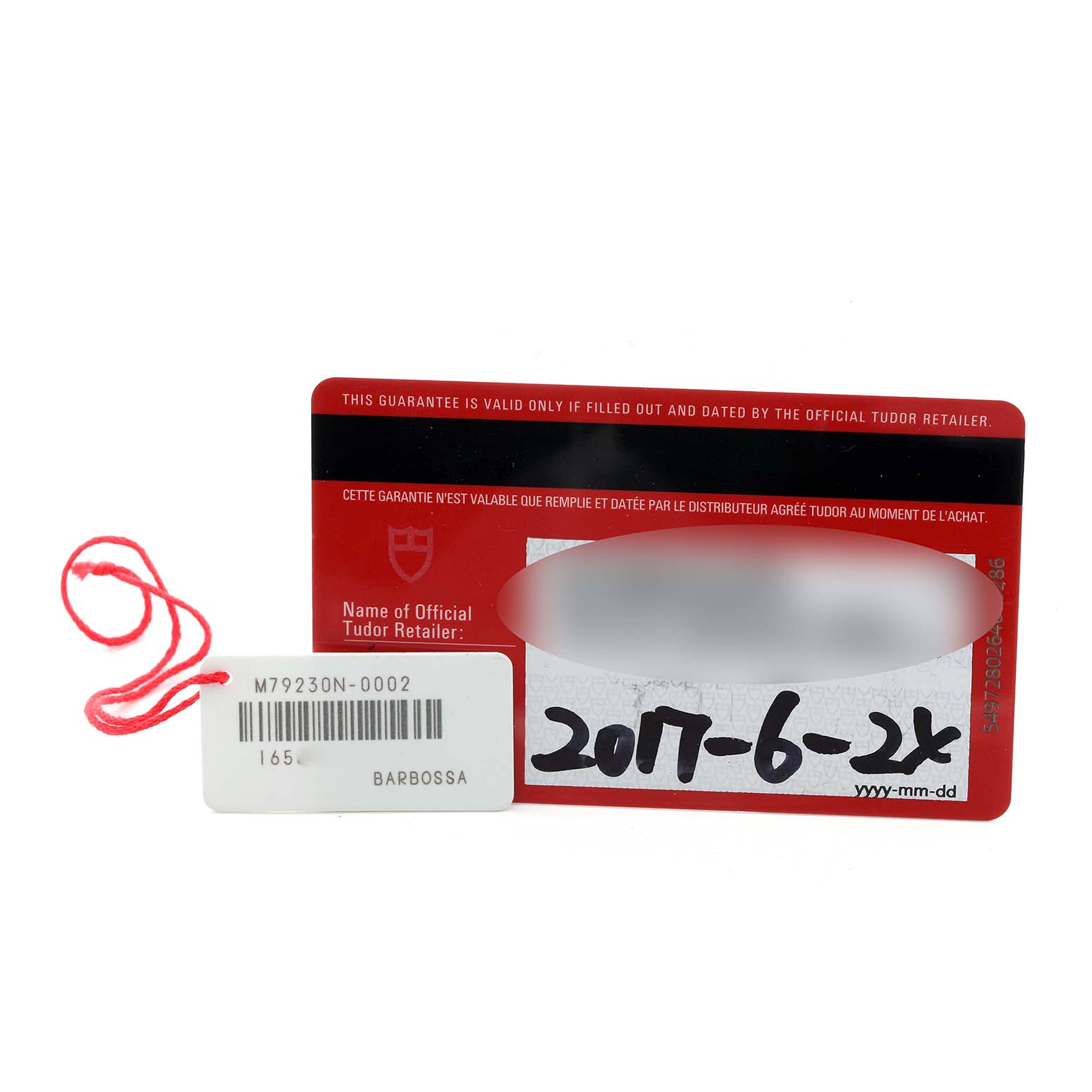 The image shows a Tudor Heritage Black Bay 79230N Men's Stainless Steel Black Dial 79230N Men's Stainless Steel Black Dial warranty card and a tag with a red string.