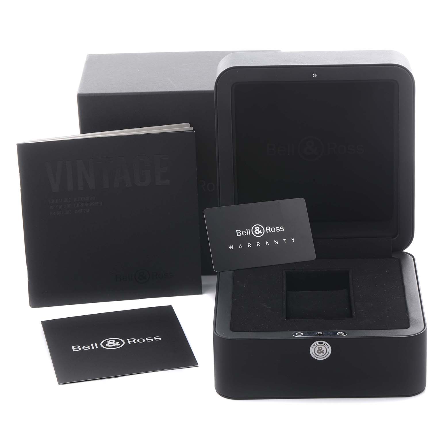 The image shows a Bell 
Ross Instruments BRV3-94-A521 Men
s Stainless Steel Black Dial BRV3-94-A521 Men
s Stainless Steel Black Dial watch box at an angled view with a warranty card and manual.