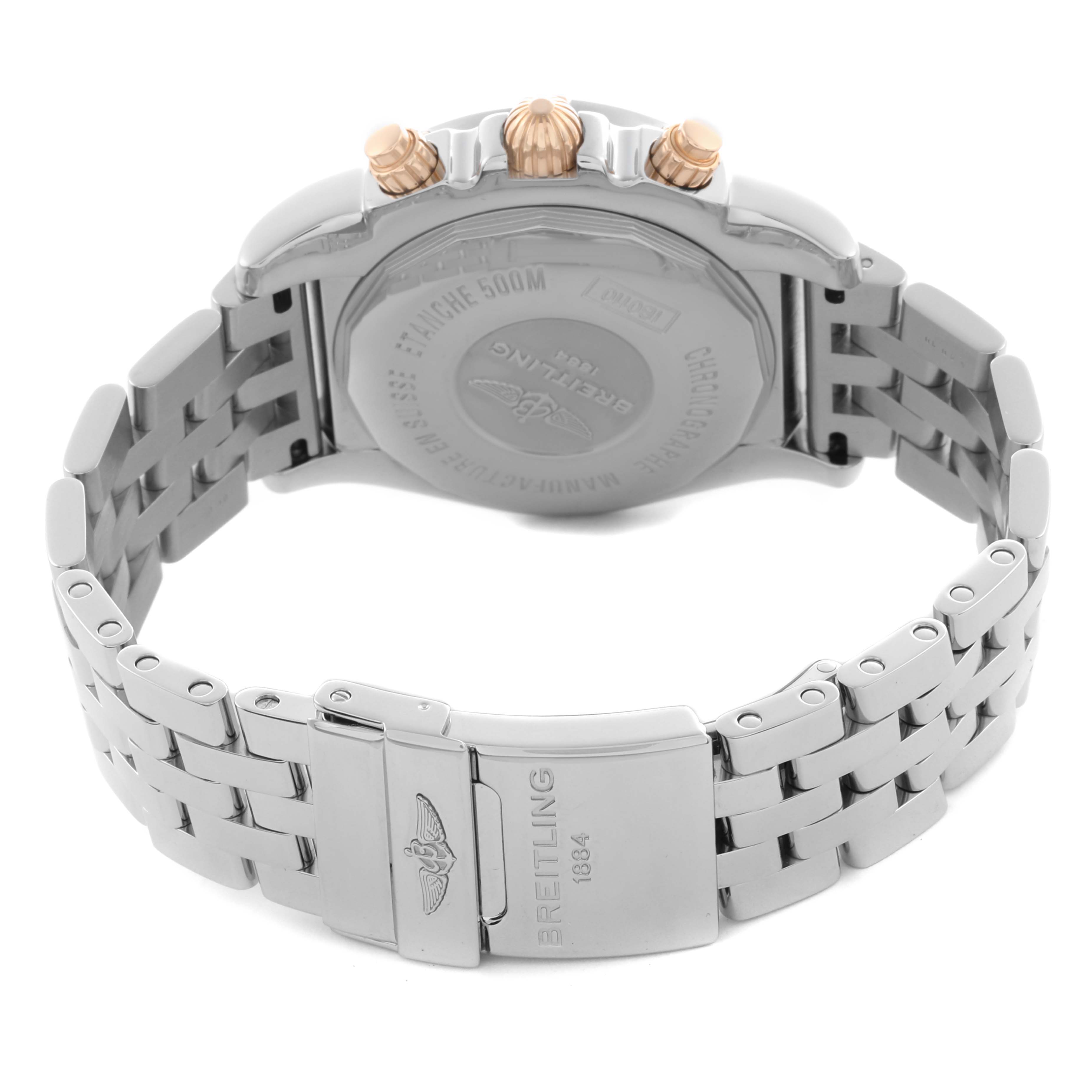 The image shows the back of a Breitling Chronomat IB0110 Men's Steel and Gold (two tone) Black Dial IB0110 Men's Steel and Gold (two tone) Black Dial watch, highlighting the clasp, bracelet, and case back with gold details on the crown and pushers.