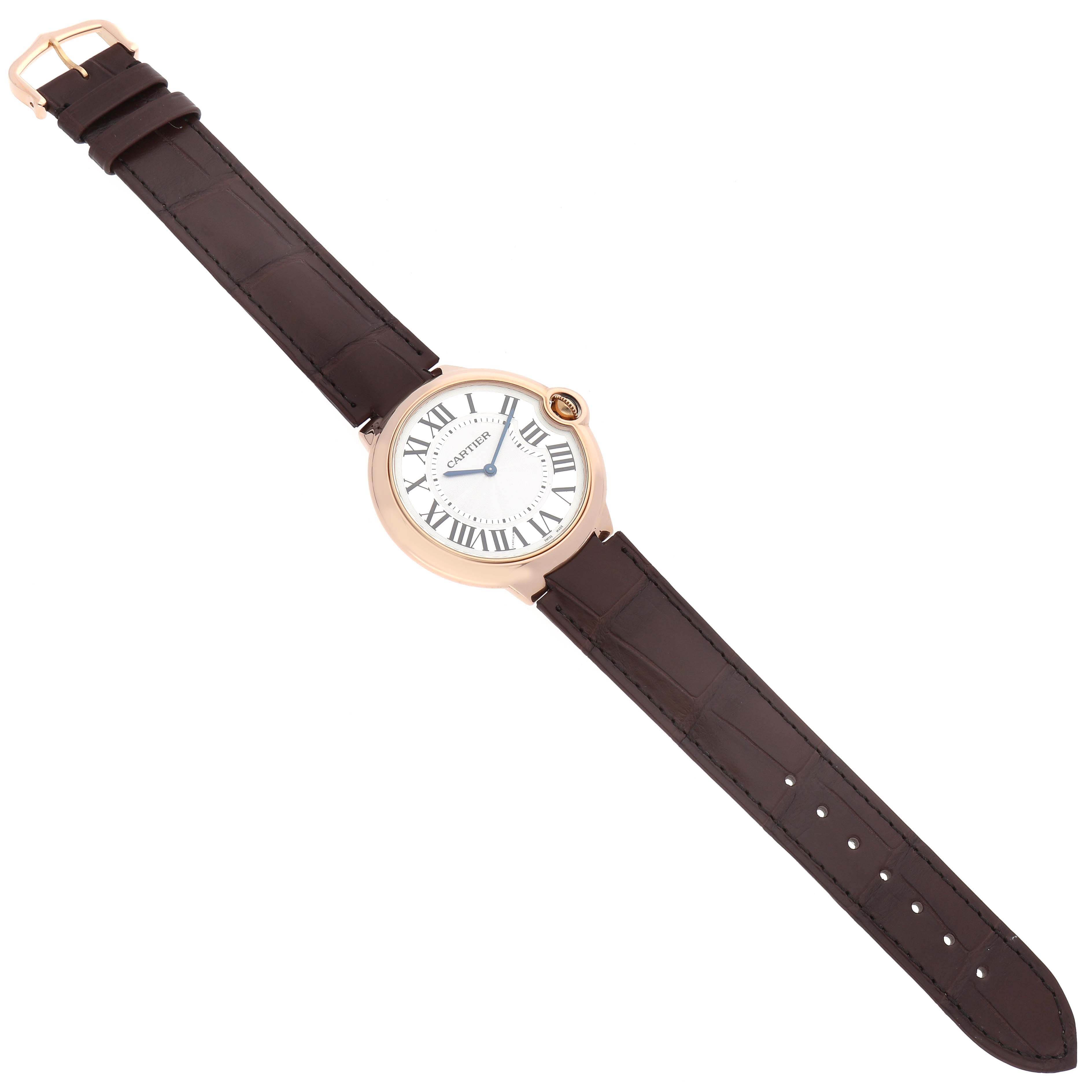 The image shows a Ballon Bleu model by Cartier from a top-down angle, displaying the complete watch with its strap, face, and buckle.