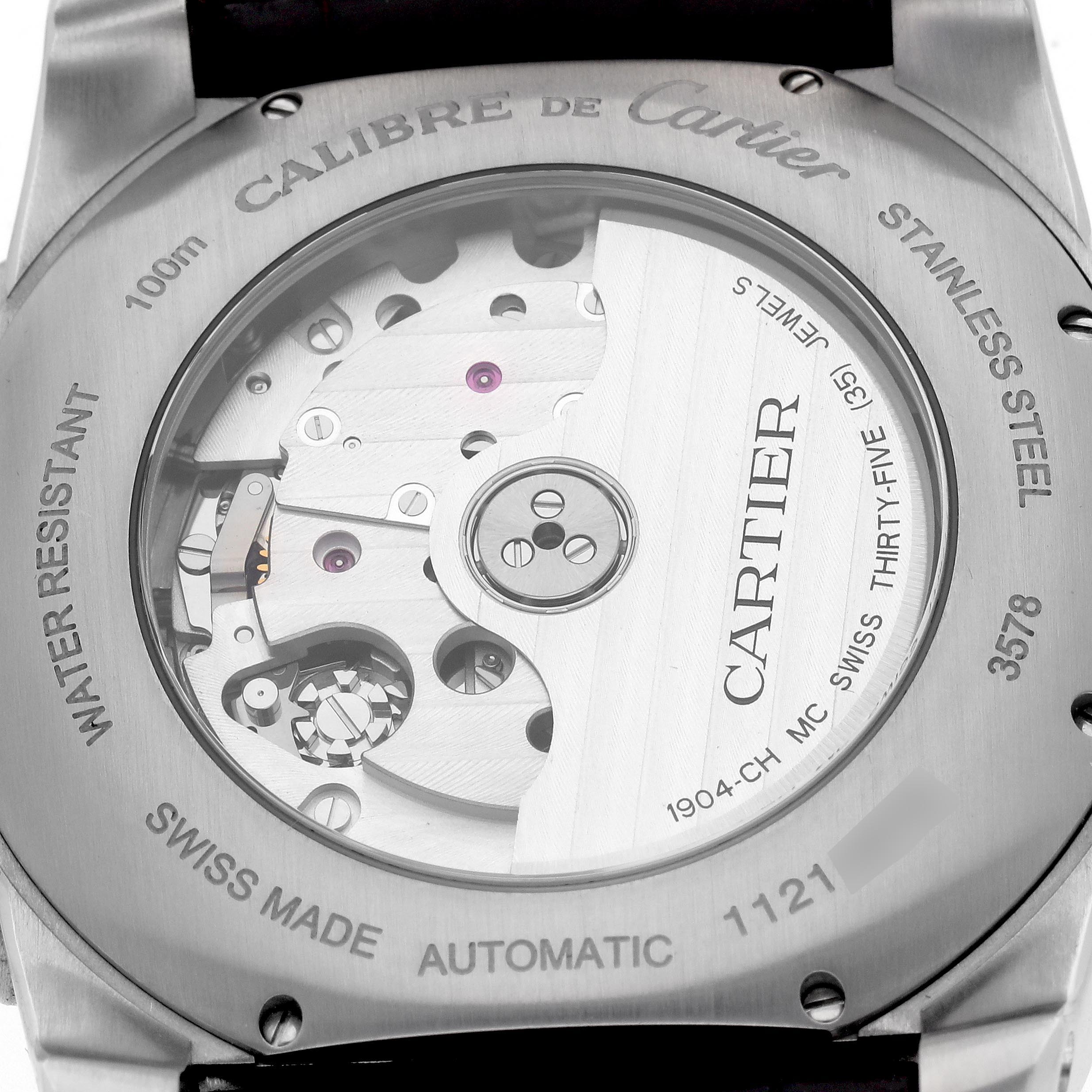The image shows the back of the Calibre de Cartier watch, highlighting its movement and engravings on the case.