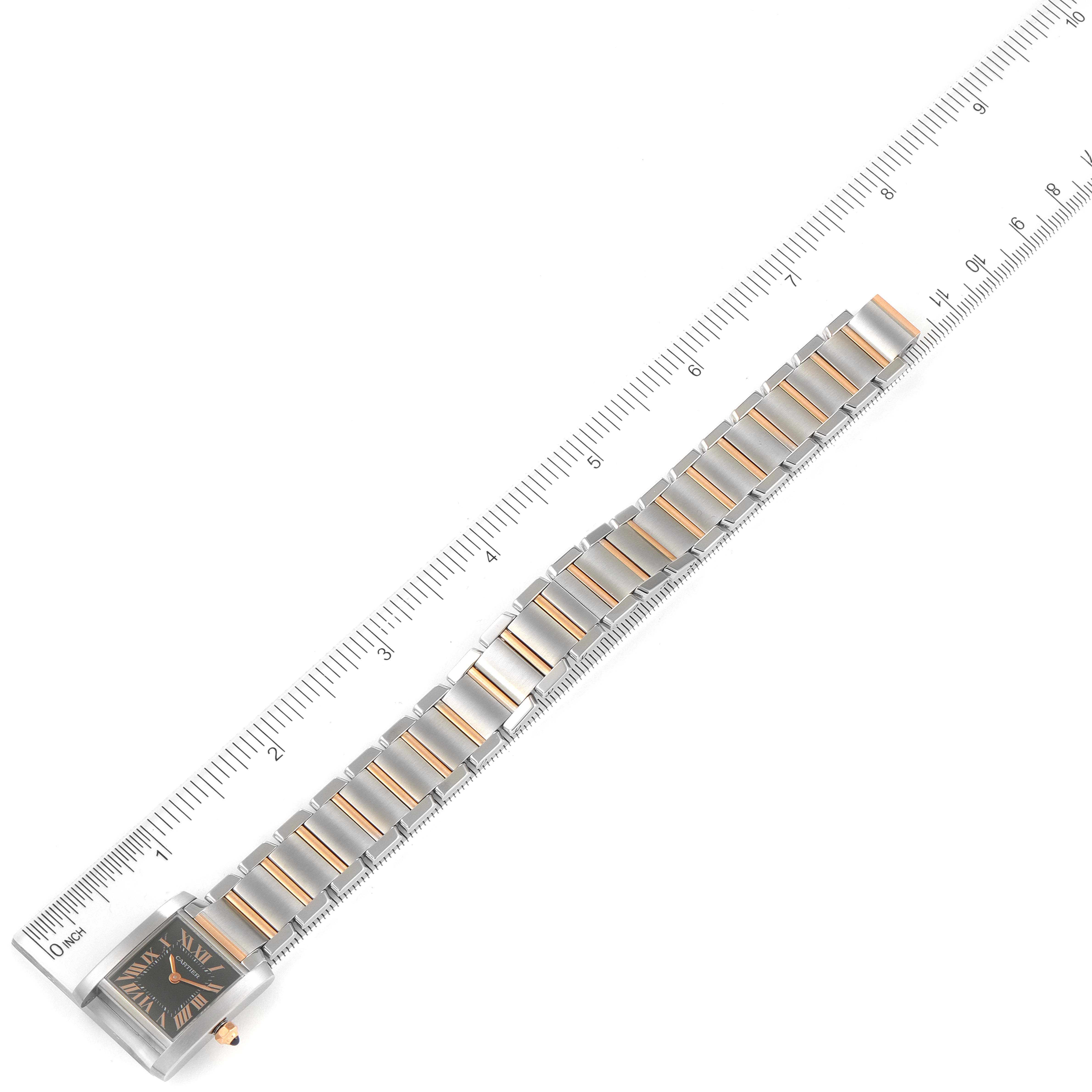 The image shows a Cartier Tank Française watch placed next to a ruler, displaying its bracelet and face from a top-down angle.