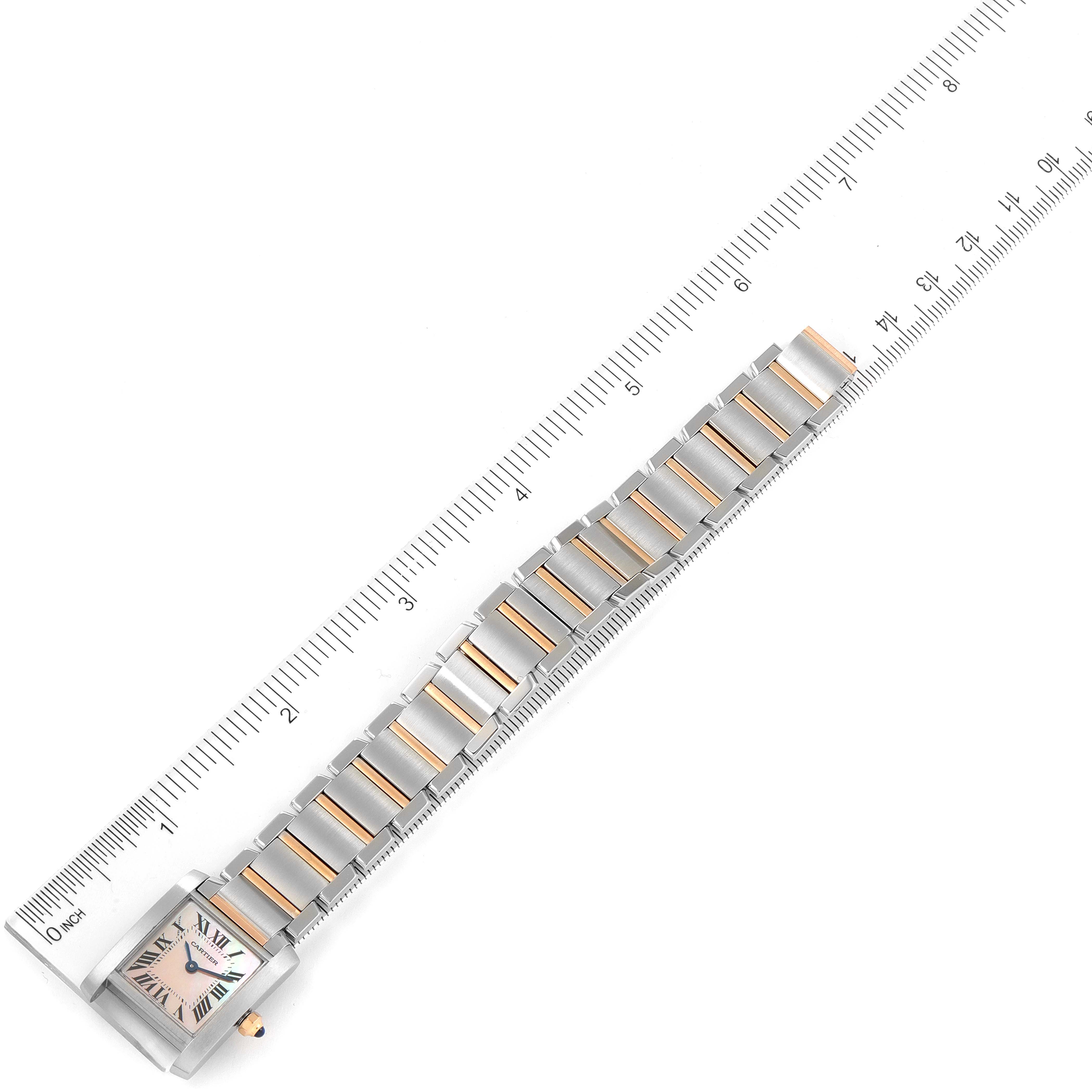 The image shows a top-down view of a Cartier Tank Française watch, with a ruler beside it for size reference.