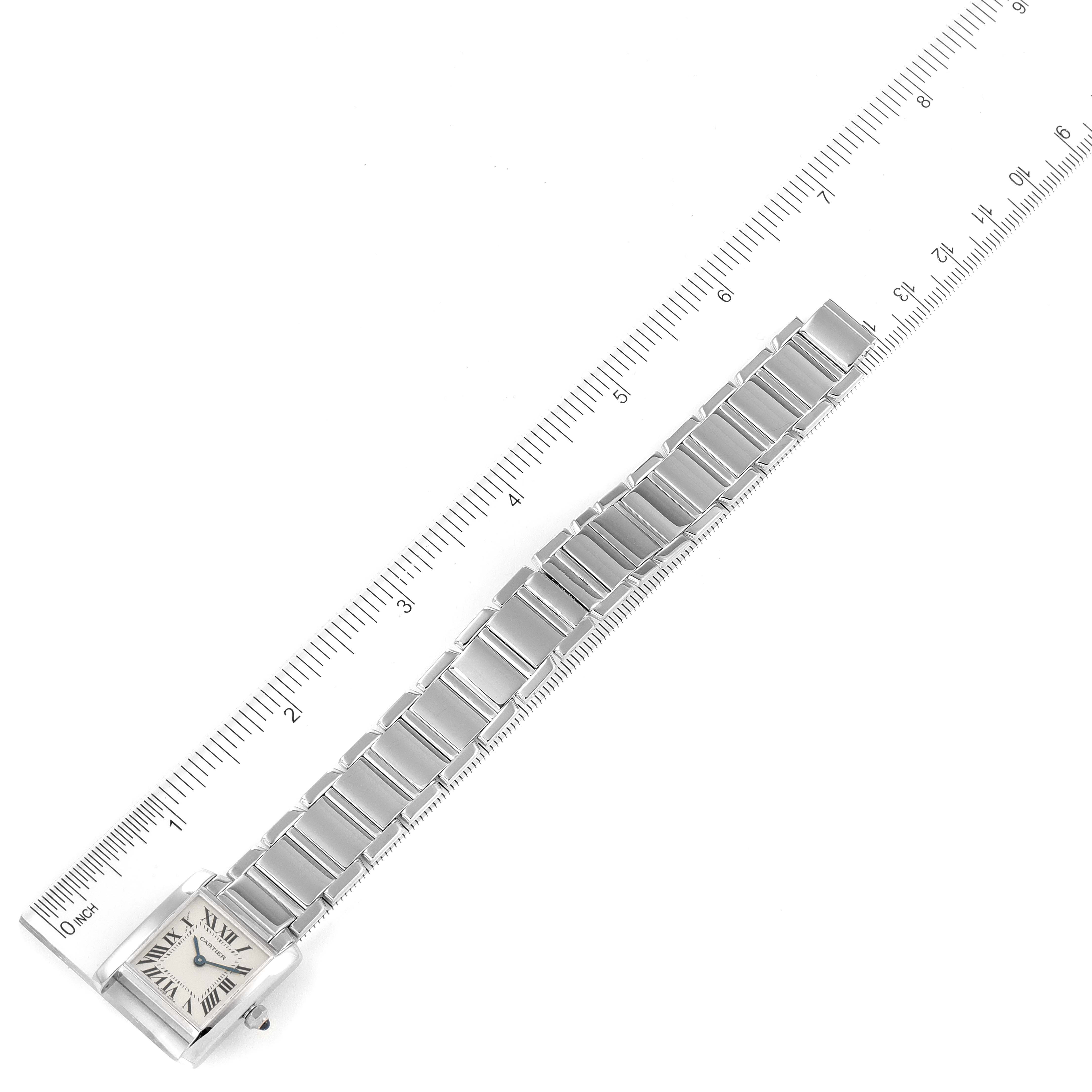 The image shows a top-down view of a Cartier Tank Francaise W50012S3 Women's White Gold Silver Dial W50012S3 Women's White Gold Silver Dial watch next to a ruler.