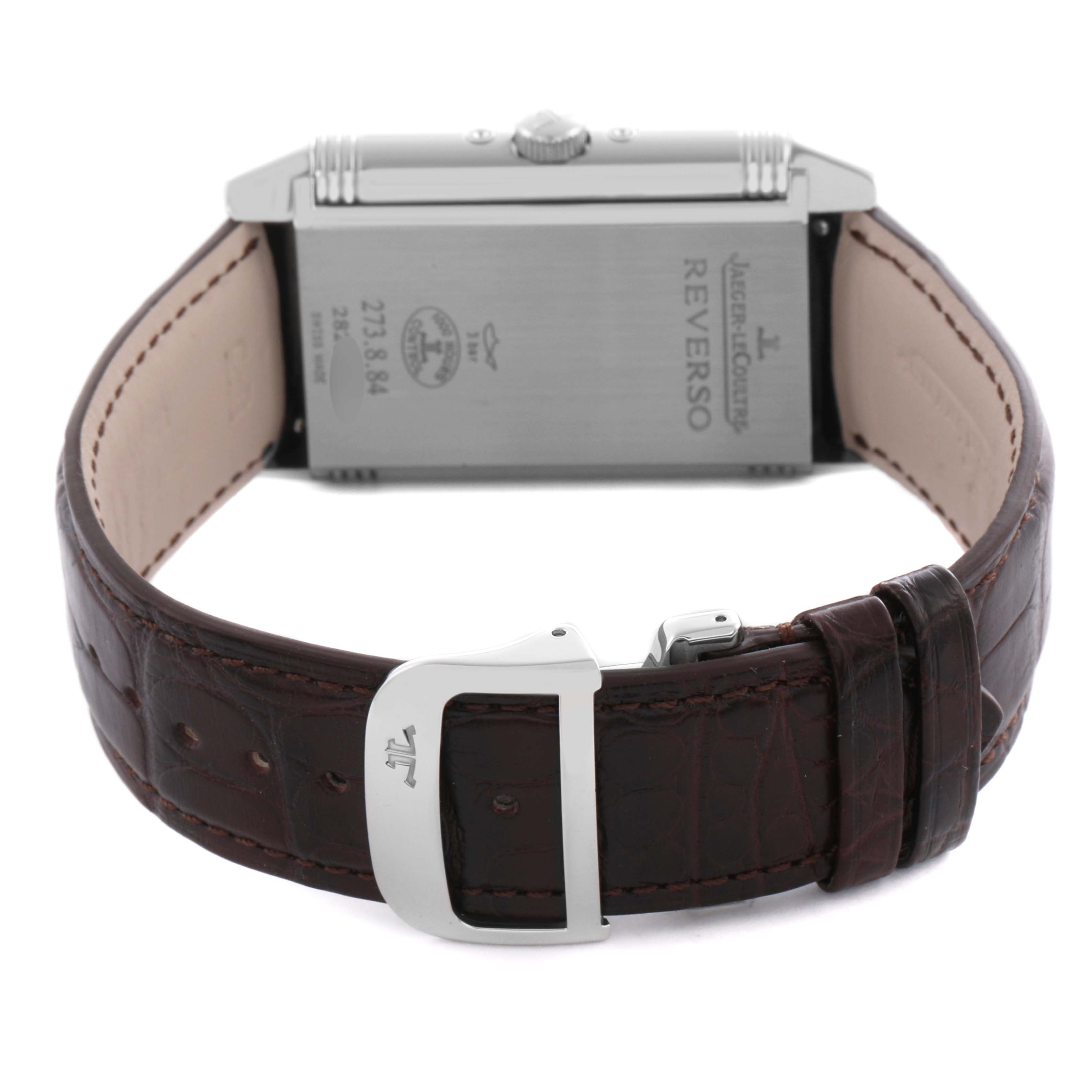 The image shows the back of the Reverso watch by Jaeger LeCoultre, highlighting the buckle and the engraved case back details.