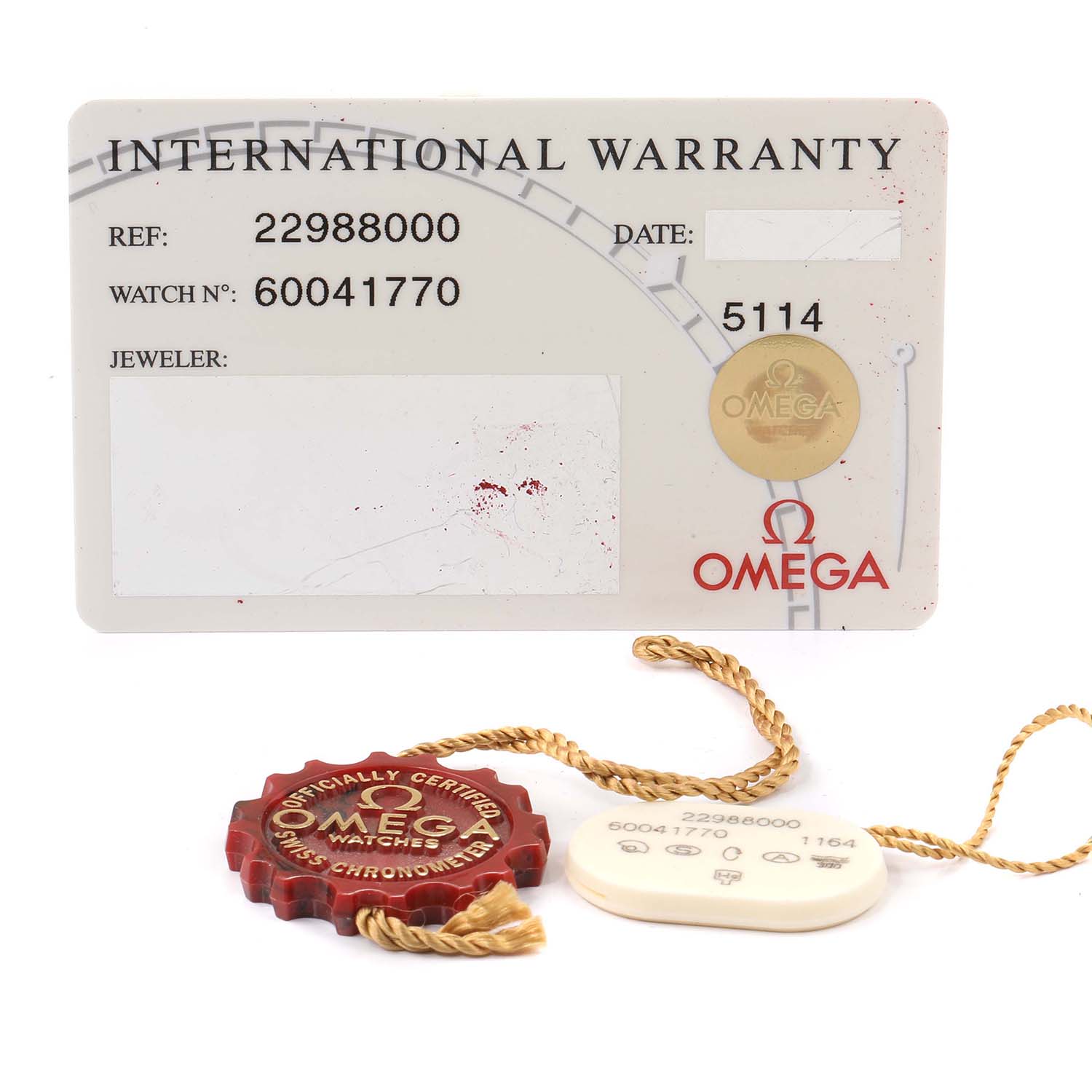 The image shows an Omega Seamaster 2298.80.00 Men
s Titanium Blue Dial 2298.80.00 Men
s Titanium Blue Dial international warranty card, a red certification tag, and a white accessory tag, laying flat.