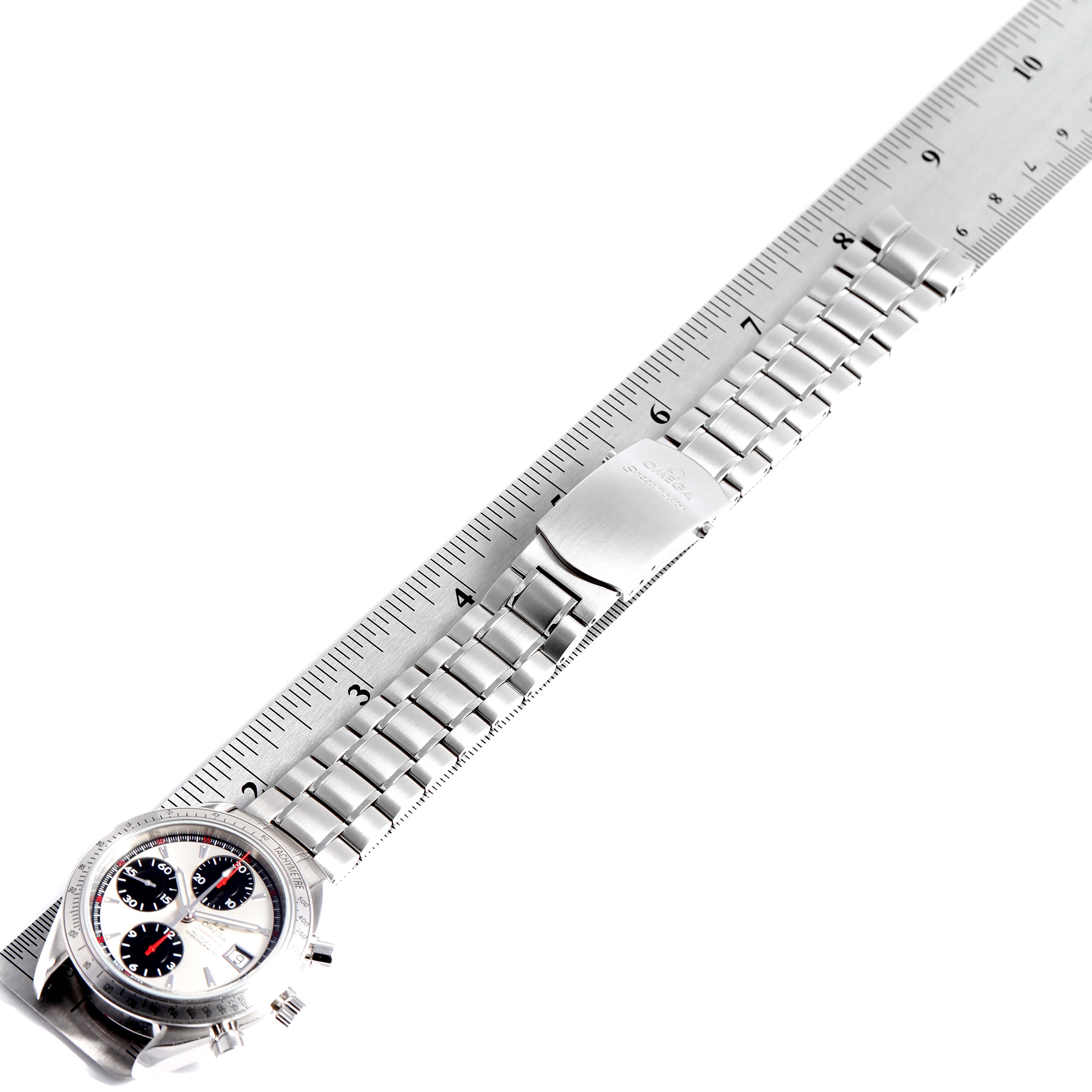 The image shows an Omega Speedmaster 3211.31.00 Men's Stainless Steel Silver Dial 3211.31.00 Men's Stainless Steel Silver Dial watch laid flat beside a ruler, highlighting its stainless steel bracelet and clasp.