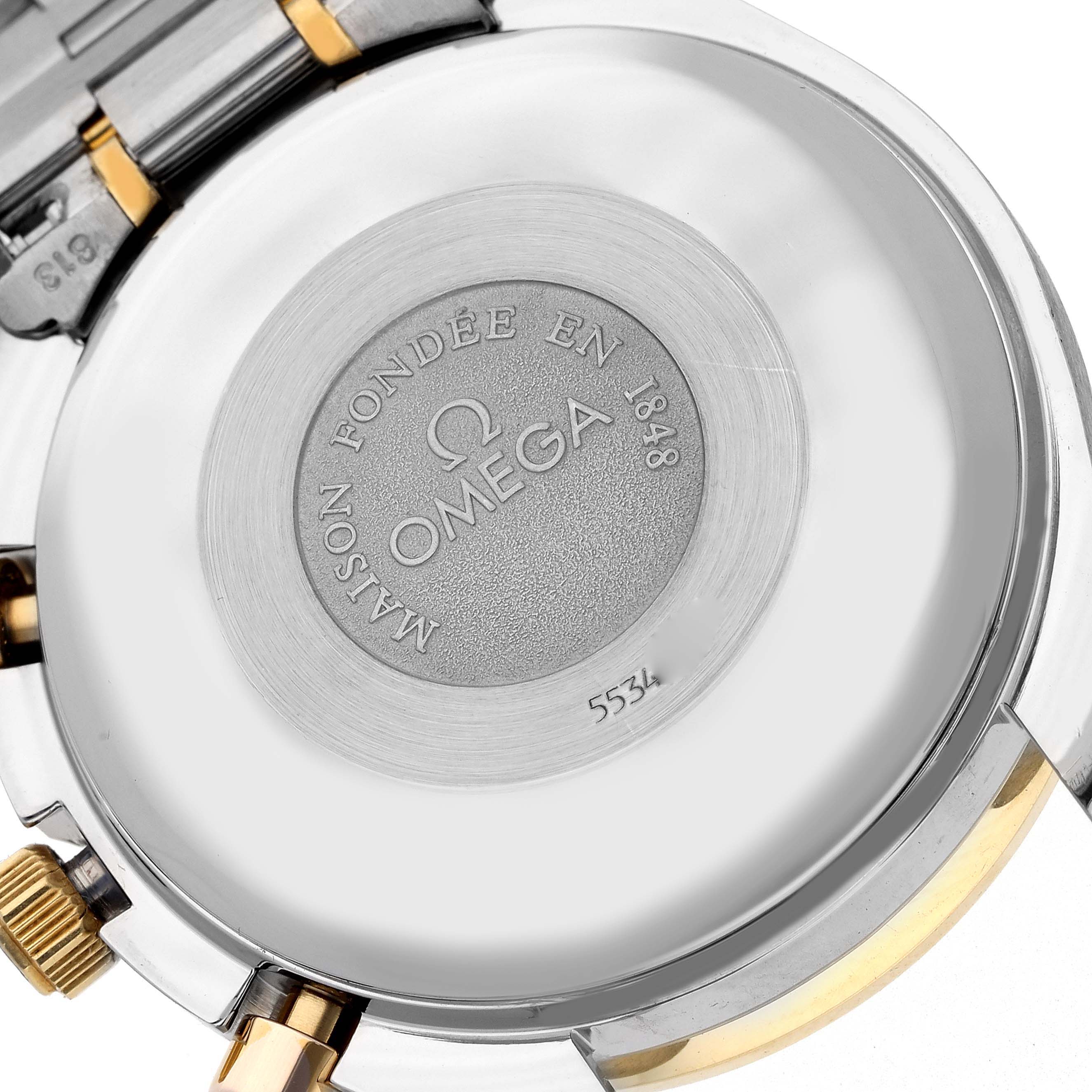 The image shows the back of the Omega Speedmaster 3321.80.00 Men's Steel and Gold (two tone) Blue Dial 3321.80.00 Men's Steel and Gold (two tone) Blue Dial watch with engraved details and part of the bracelet visible.