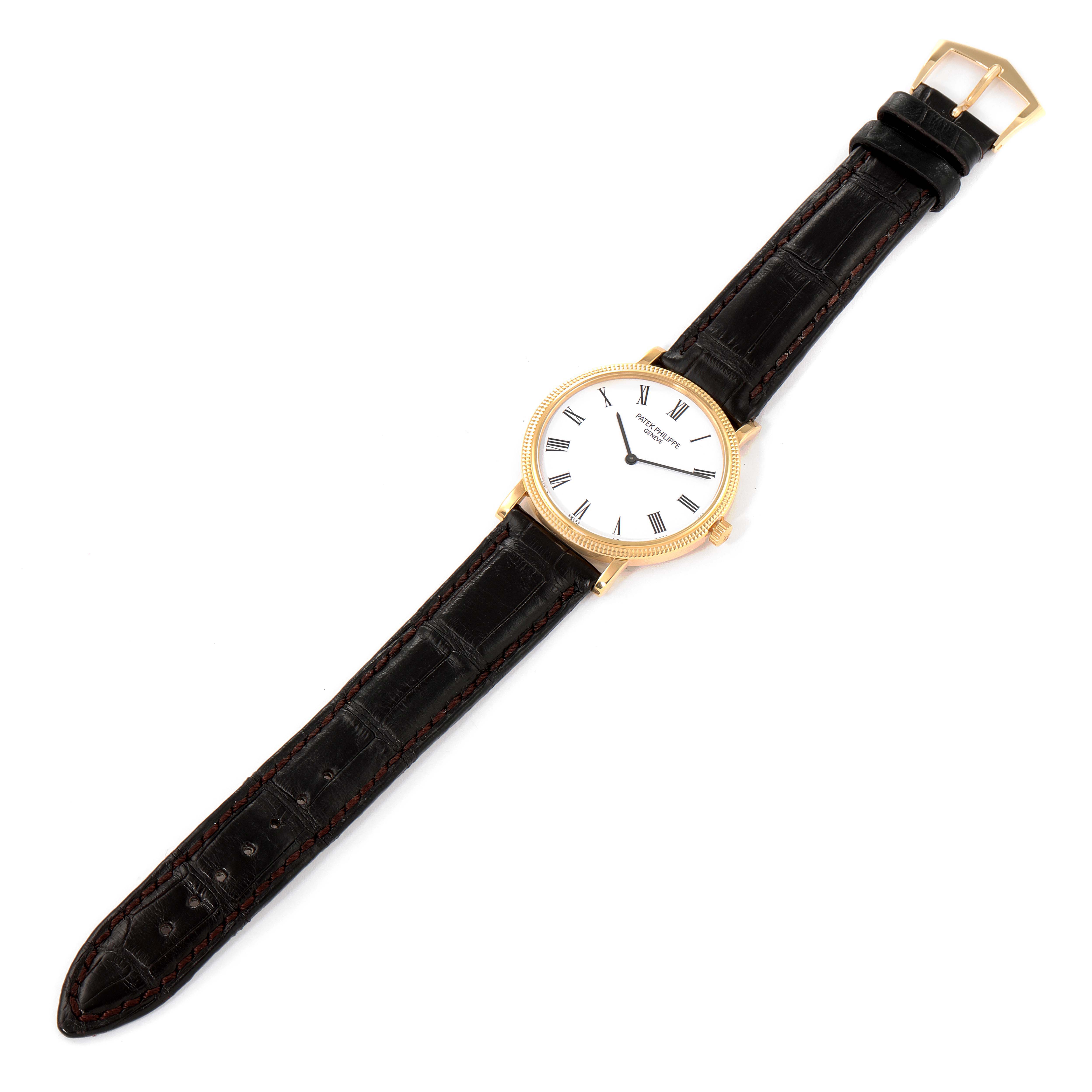 The Patek Philippe Calatrava 5120J Men
s Yellow Gold White Dial 5120J Men
s Yellow Gold White Dial watch is shown from a top-down angle, displaying the face, case, and leather strap.