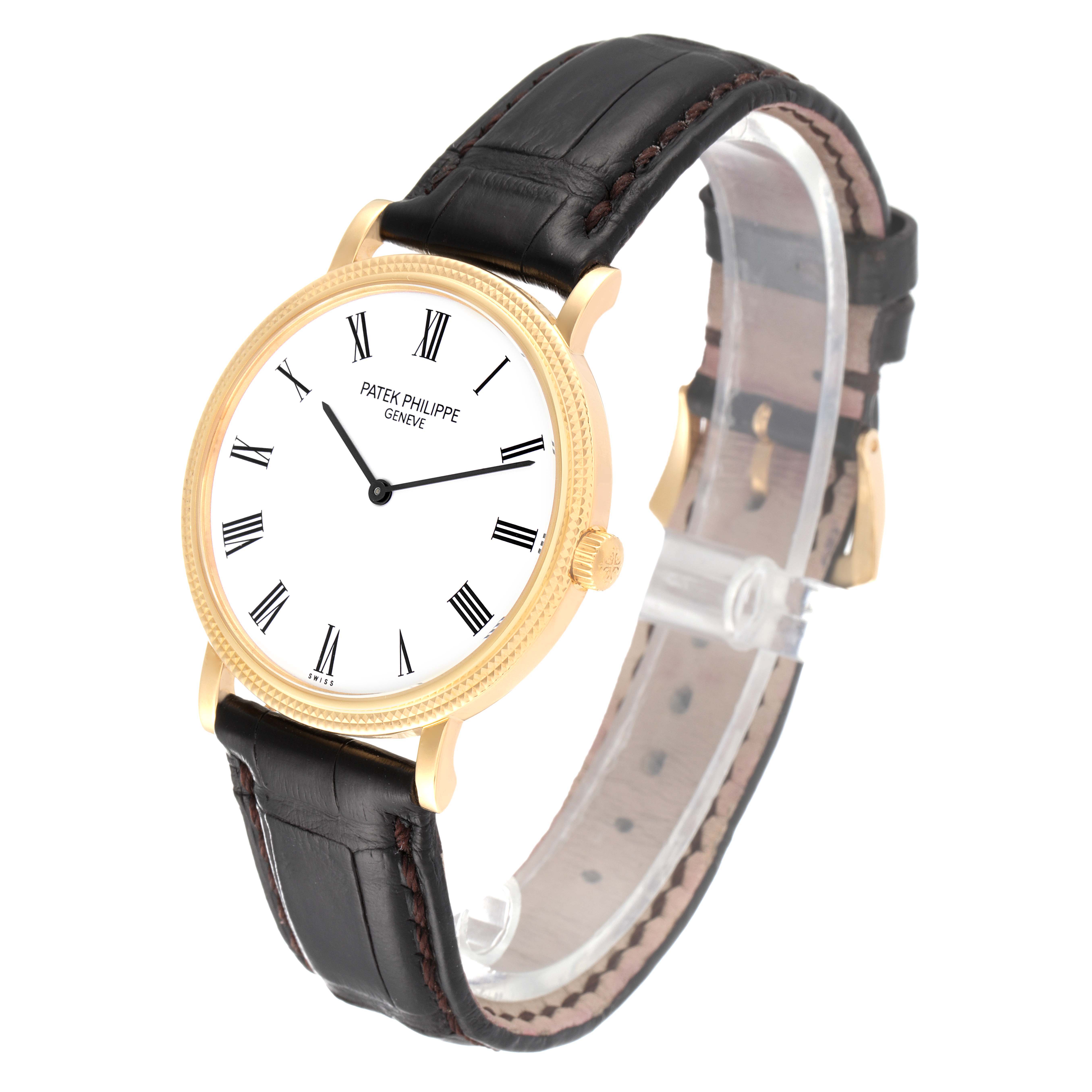 The image shows a side angle view of a Patek Philippe Calatrava 5120J Men
s Yellow Gold White Dial 5120J Men
s Yellow Gold White Dial watch, displaying its white dial, gold case, and black leather strap.