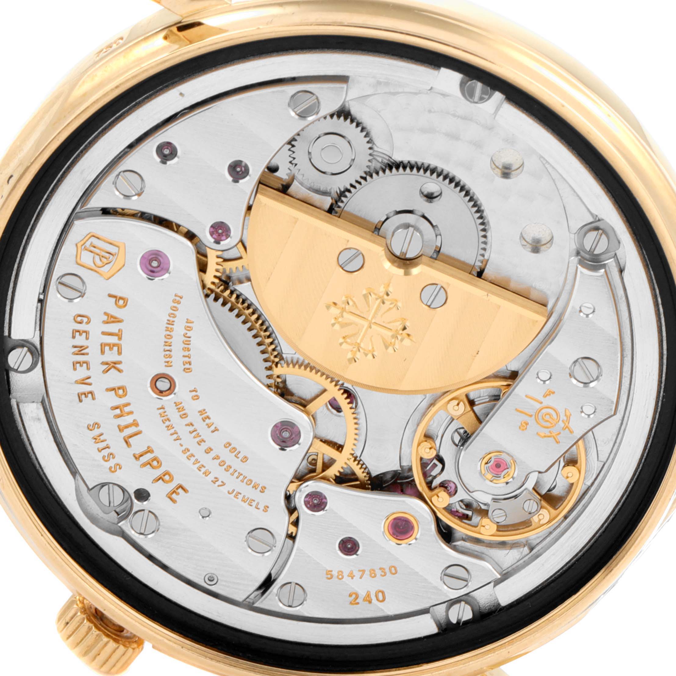 The image shows the movement
s intricate parts and gears, viewed from the back of a Patek Philippe Calatrava 5120J Men
s Yellow Gold White Dial 5120J Men
s Yellow Gold White Dial watch.
