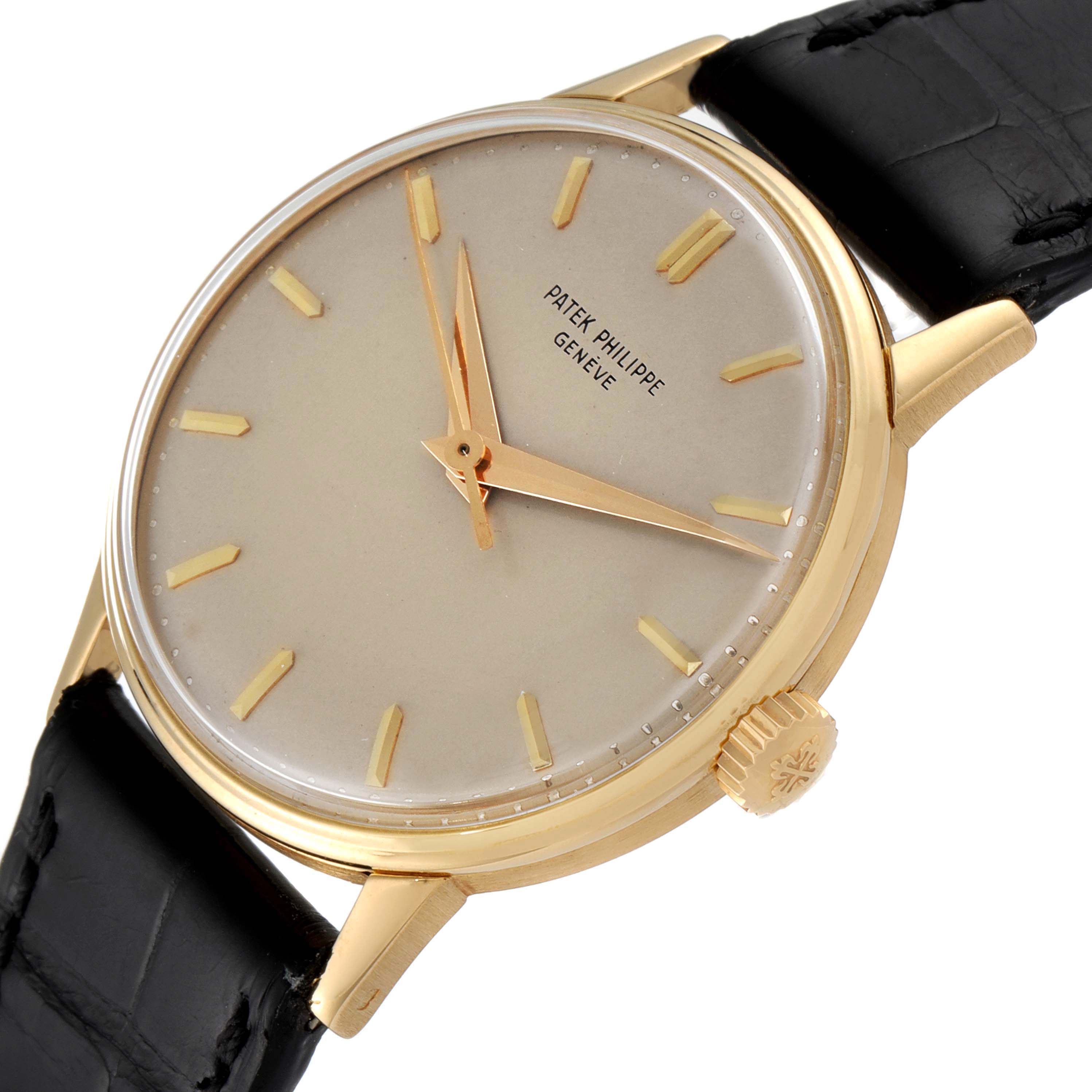 The image shows a close-up angle of a Vintage Patek Philippe watch, highlighting the dial, gold case, and black strap.
