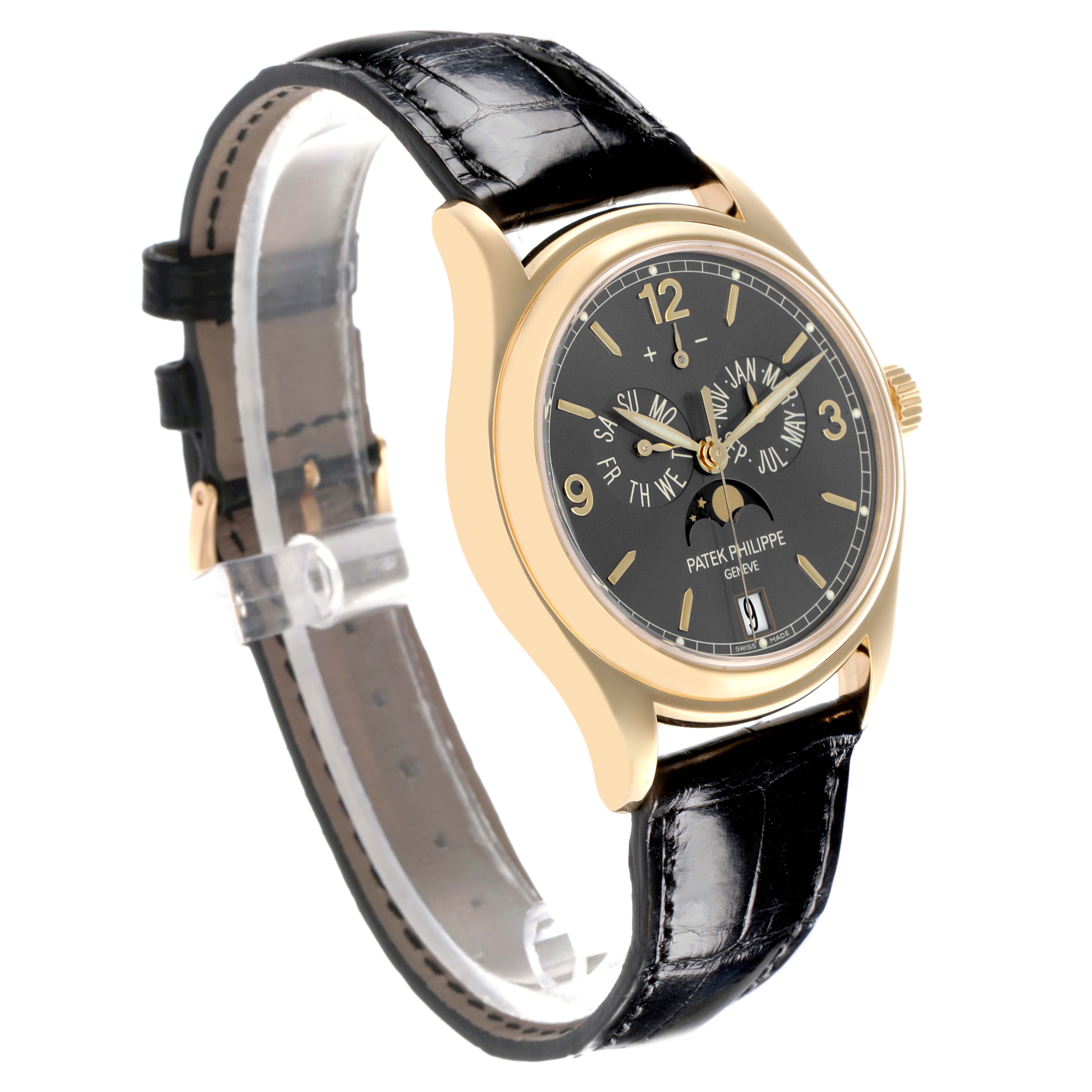 The Patek Philippe Complications 5146J-010 Men's Yellow Gold Grey Dial 5146J-010 Men's Yellow Gold Grey Dial watch is shown at a three-quarter angle, highlighting the face, black strap, and gold case.