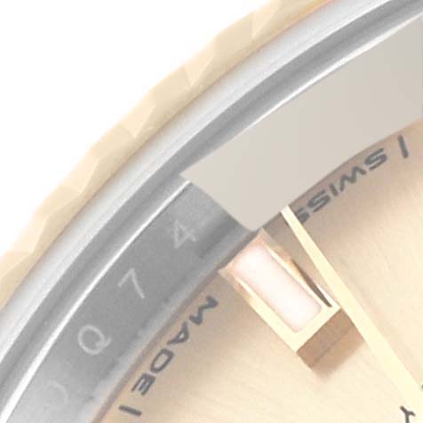 This close-up image of a Rolex Datejust 279173 Women's Steel and Gold (two tone) Champagne Dial 279173 Women's Steel and Gold (two tone) Champagne Dial watch shows part of the bezel, dial, and minute hand.