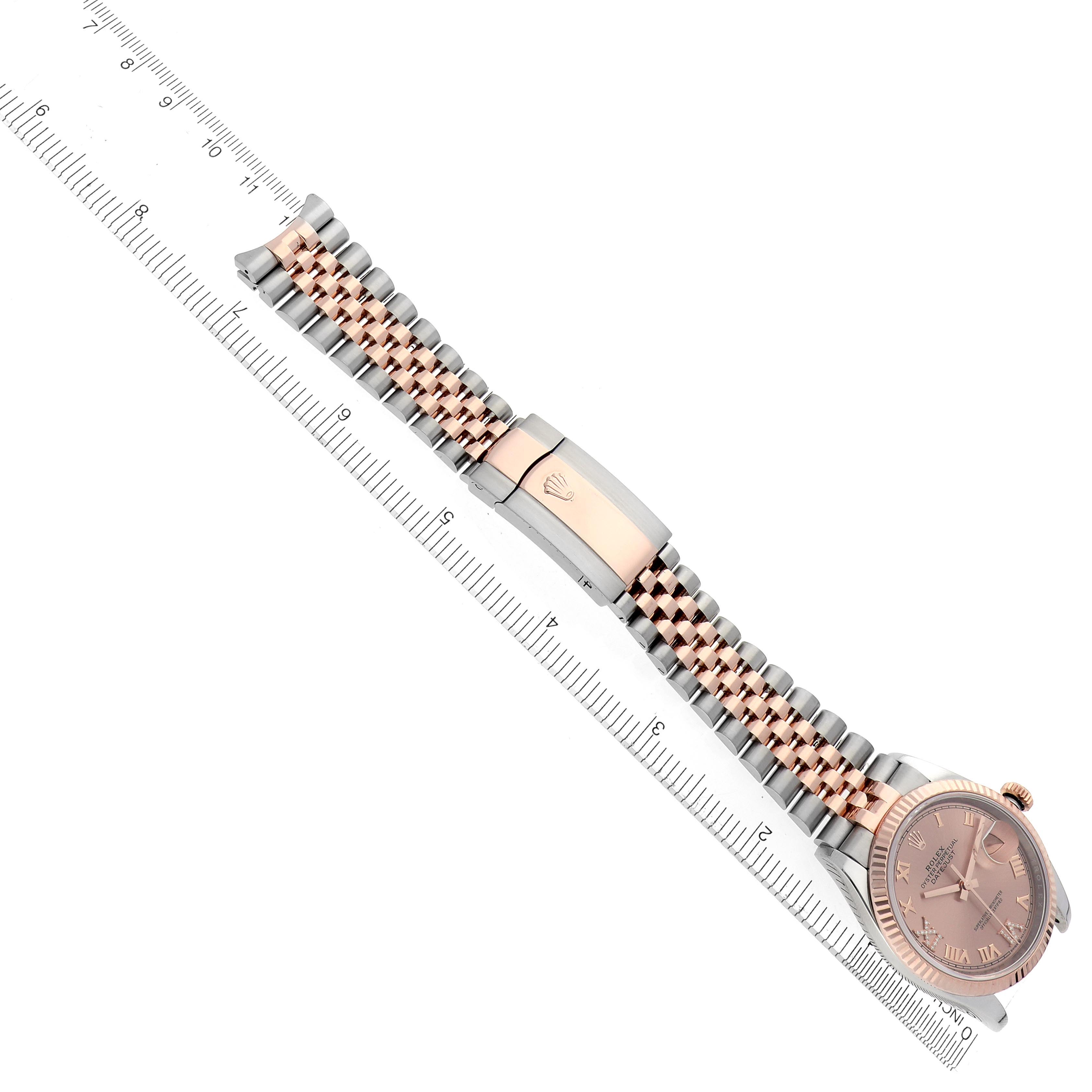 The image shows a Rolex Datejust 126231 Men's Steel and Gold (two tone) Pink Dial 126231 Men's Steel and Gold (two tone) Pink Dial watch at an angled top view, highlighting the dial, bracelet, and clasp alongside a ruler for scale.