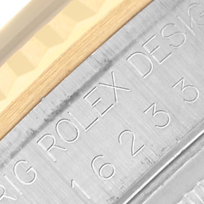 The image shows an angled close-up of the side, featuring the engraved model number of a Rolex Datejust 16233 Men's Steel and Gold (two tone) Black Dial 16233 Men's Steel and Gold (two tone) Black Dial.