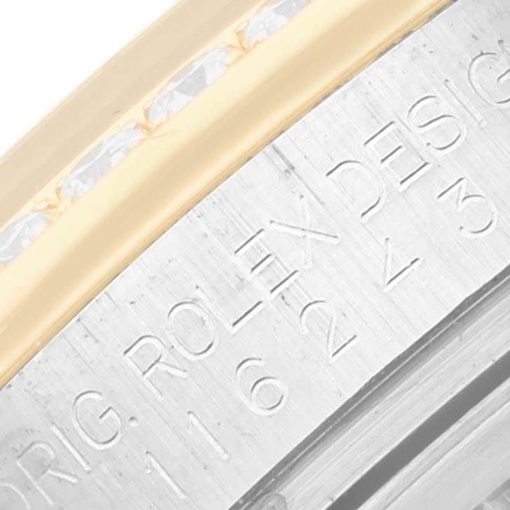 This close-up image shows the engraved details on the bezel of a Rolex Datejust 116243 Men's Steel and Gold (two tone) Black Dial 116243 Men's Steel and Gold (two tone) Black Dial watch.