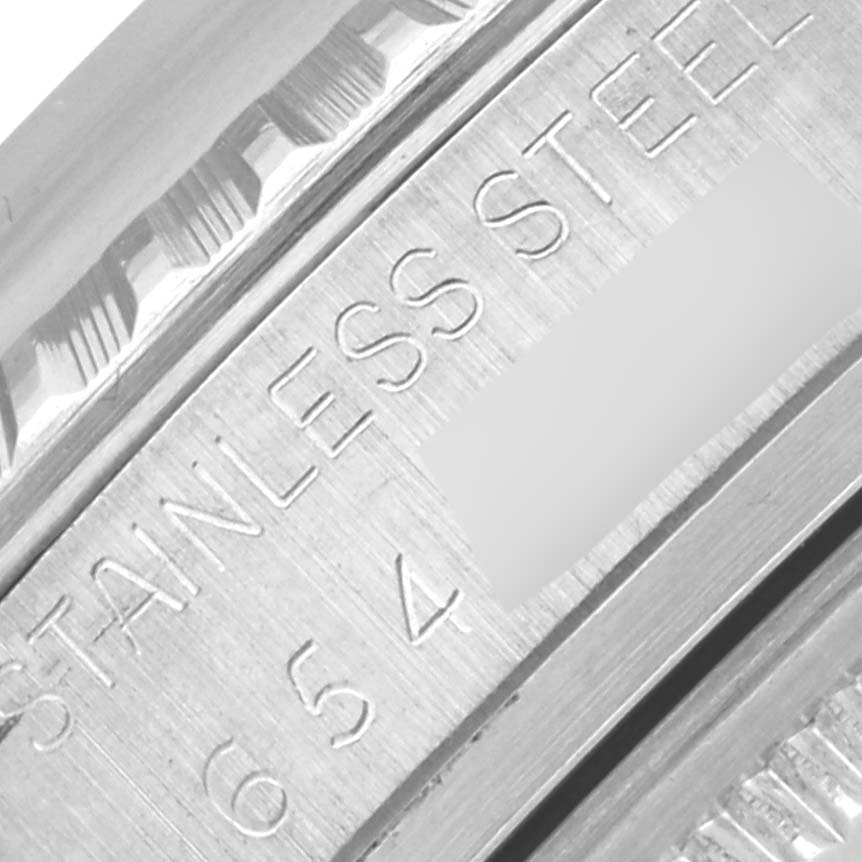 The image shows a close-up of the Rolex Datejust 16030 Men's Stainless Steel Silver Dial 16030 Men's Stainless Steel Silver Dial's stainless steel case with engraved text.