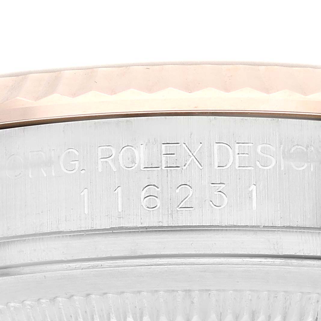 This close-up image shows the serial number and part of the fluted bezel of a Rolex Datejust 116231 Men's Steel and Gold (two tone) Pink Dial 116231 Men's Steel and Gold (two tone) Pink Dial watch.