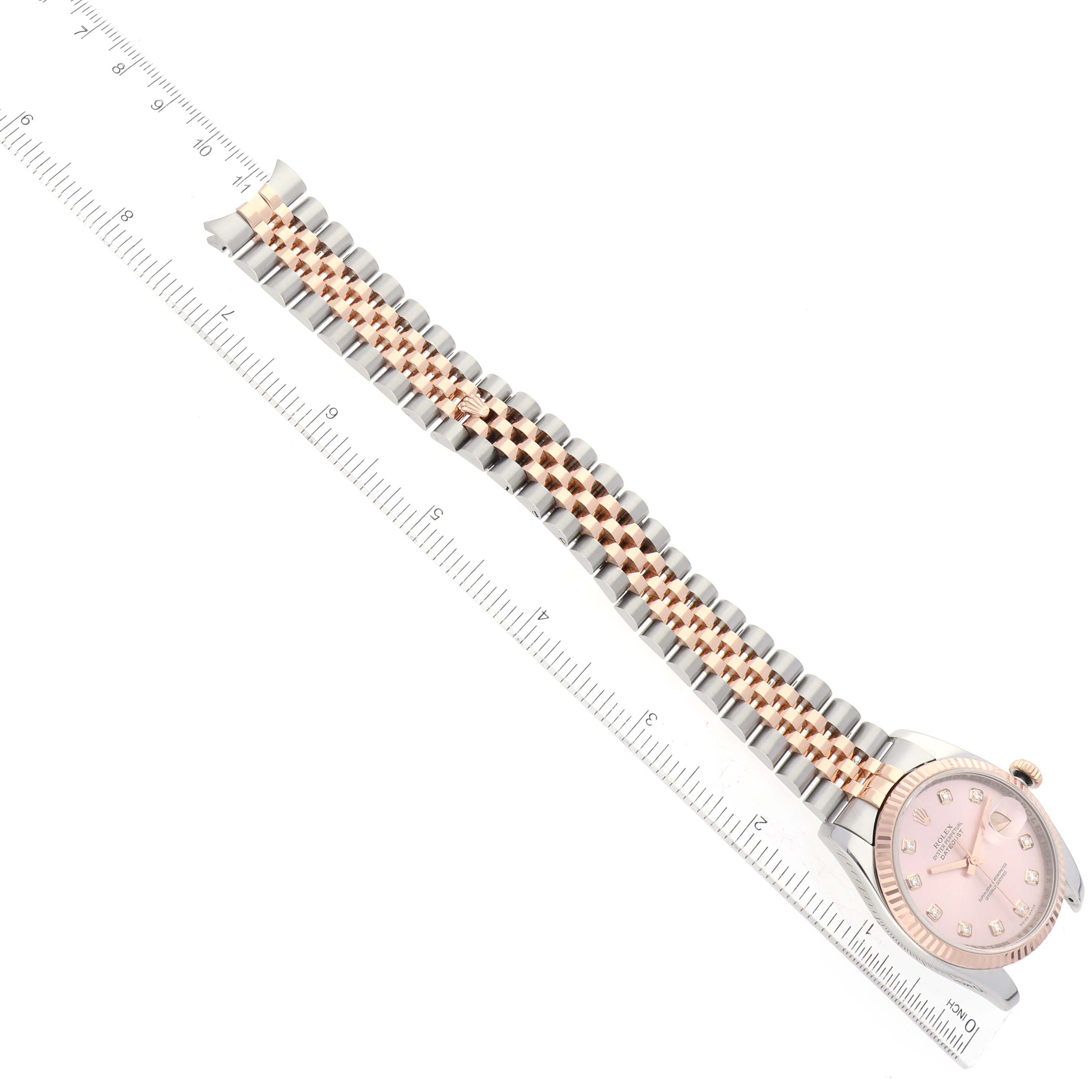 The image shows a top-down view of a Rolex Datejust 116231 Men's Steel and Gold (two tone) Pink Dial 116231 Men's Steel and Gold (two tone) Pink Dial watch, featuring its dial and bracelet next to a ruler.
