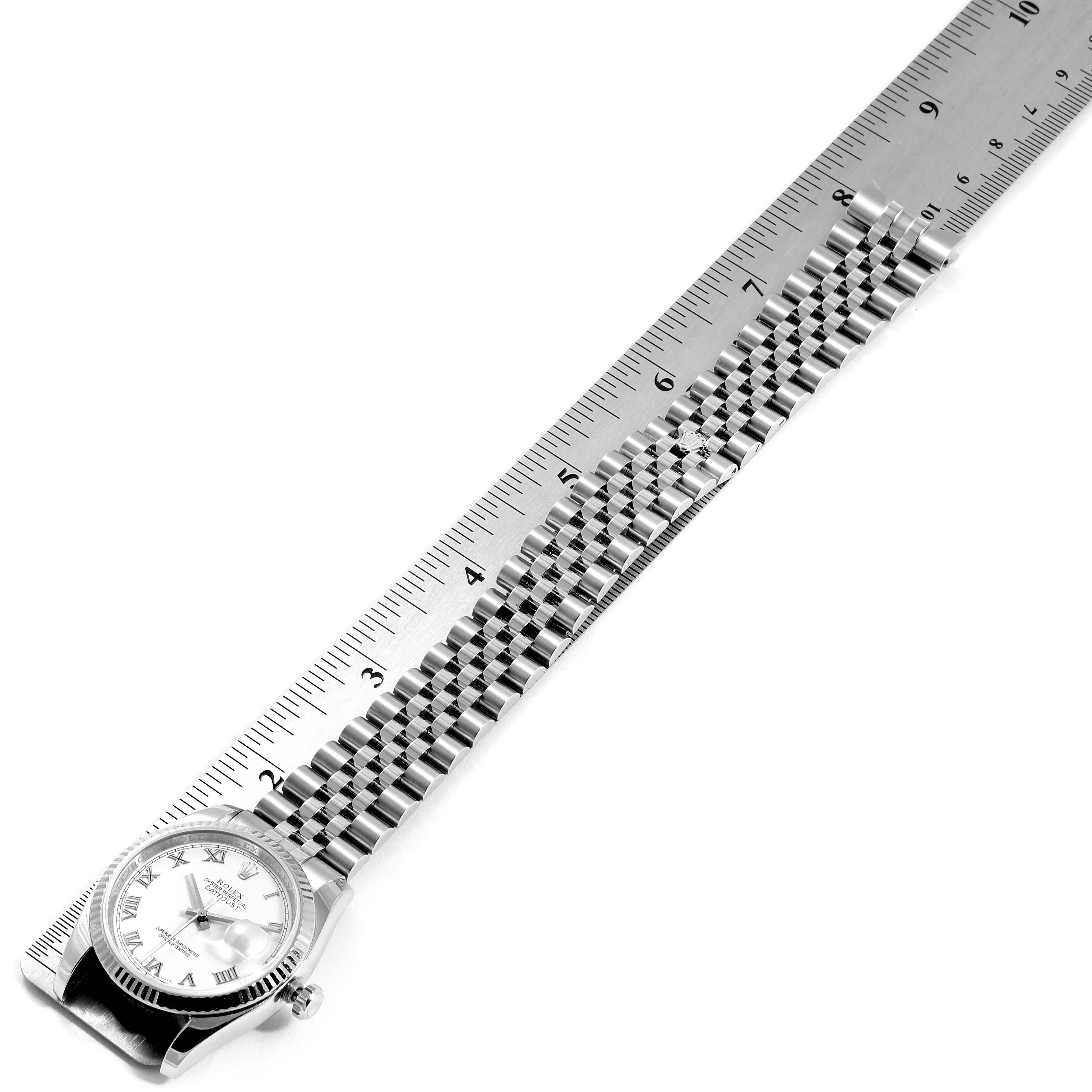 The image shows a Rolex Datejust 116234 Men's Stainless Steel White Dial 116234 Men's Stainless Steel White Dial watch aligned with a ruler, highlighting its face and bracelet.