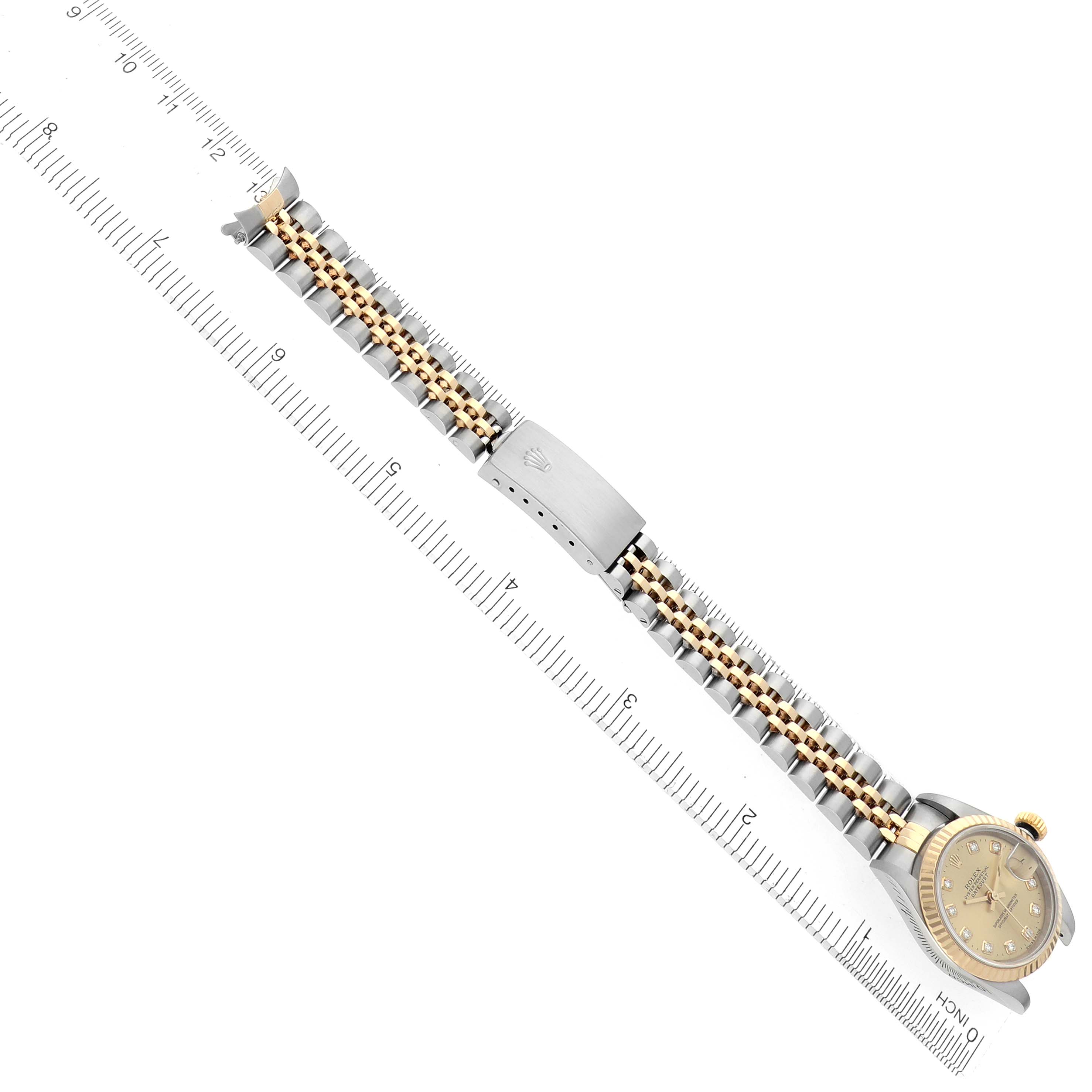 The Rolex Datejust 79173 Women's Steel and Gold (two tone) Champagne Dial 79173 Women's Steel and Gold (two tone) Champagne Dial watch is shown from a top-down angle, displaying the face and full metal bracelet alongside a ruler for scale.
