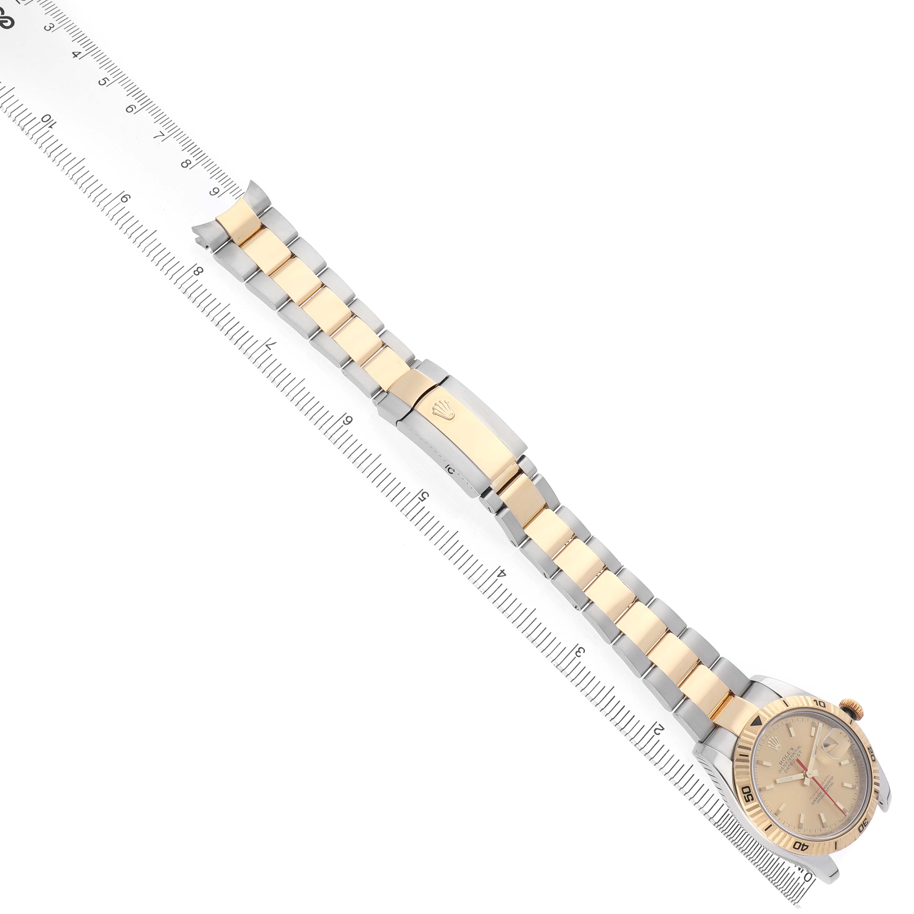 The Rolex Turn-o-Graph 116263 Men's Steel and Gold (two tone) Champagne Dial watch is shown from a top-down angle, displaying the face, bezel, and two-tone bracelet alongside a ruler.