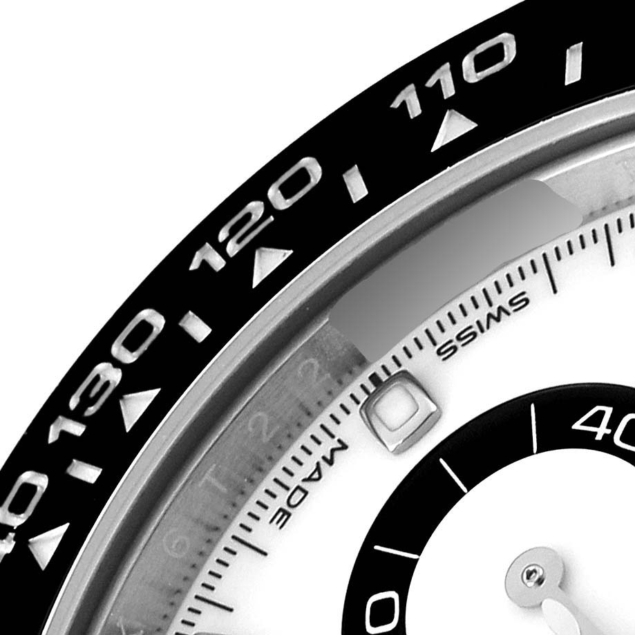 The image shows a close-up of the bezel, part of the dial, and subdial of a Rolex Daytona 116500 Men's Stainless Steel White Dial 116500 Men's Stainless Steel White Dial model watch.