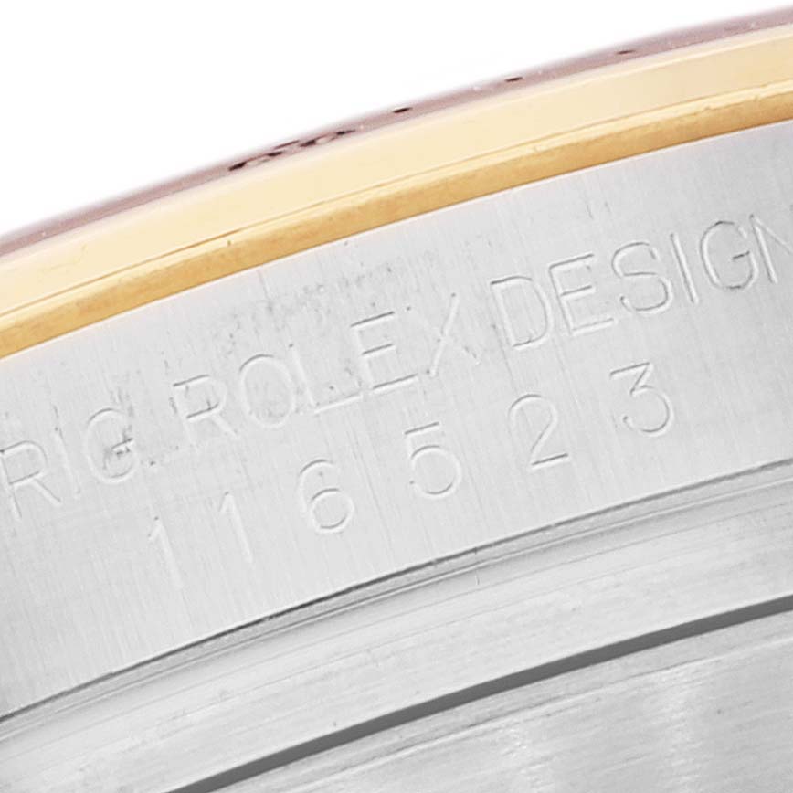 The image shows a close-up of the side inscription and serial number of a Rolex Daytona 116523 Men's Steel and Gold (two tone) Mother of Pearl Dial 116523 Men's Steel and Gold (two tone) Mother of Pearl Dial watch.