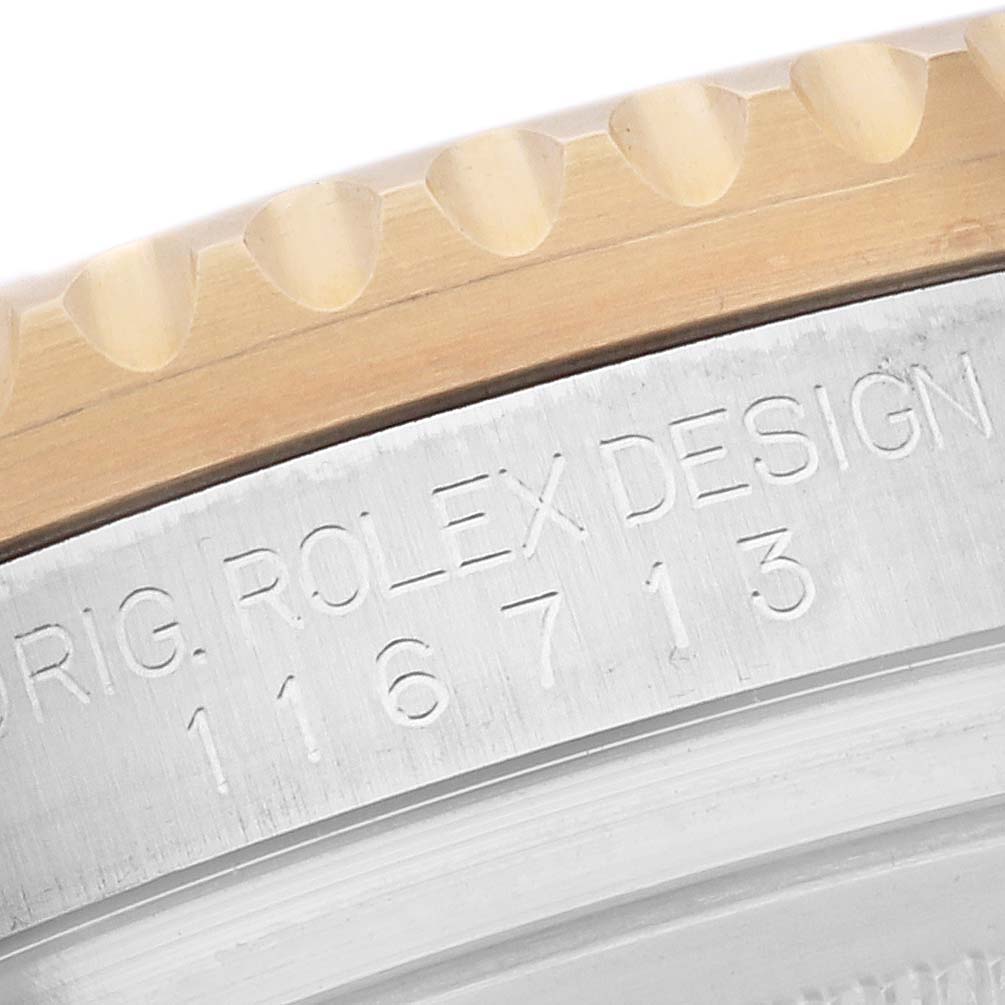 This is a close-up view of the edge and part of the bezel of a Rolex GMT-Master 116713 Men
s Steel and Gold (two tone) Black Dial 116713 Men
s Steel and Gold (two tone) Black Dial watch, showing the model number engraved.
