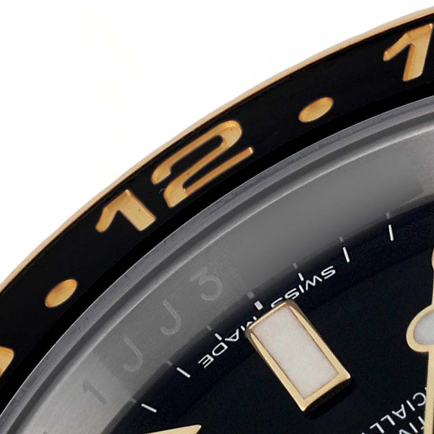 This image shows a close-up of the bezel and part of the dial of a Rolex GMT-Master 116713 Men
s Steel and Gold (two tone) Black Dial 116713 Men
s Steel and Gold (two tone) Black Dial watch.