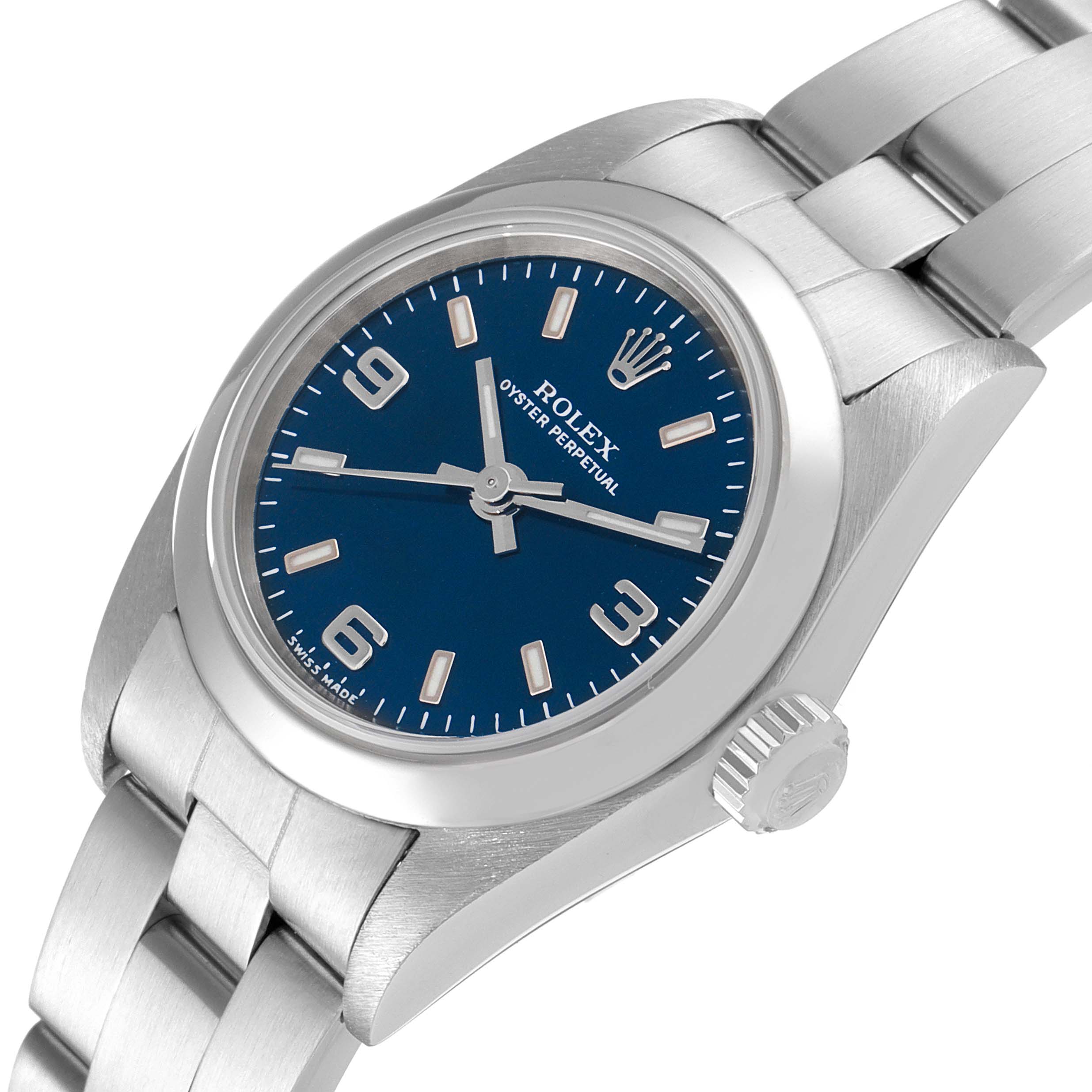 The image shows an angled close-up of a Rolex Oyster Perpetual 76080 Women's Stainless Steel Blue Dial 76080 Women's Stainless Steel Blue Dial watch, highlighting its blue dial, crown, and part of the metal bracelet.