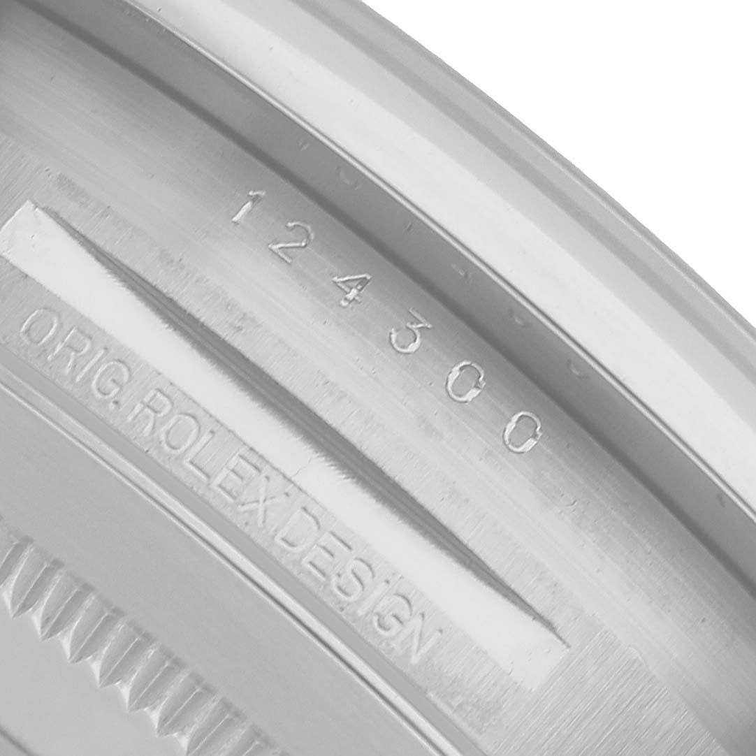 The image shows the engraved case back of a Rolex Oyster Perpetual 124300 Men's Stainless Steel Silver Dial, featuring its model number and designer inscription.