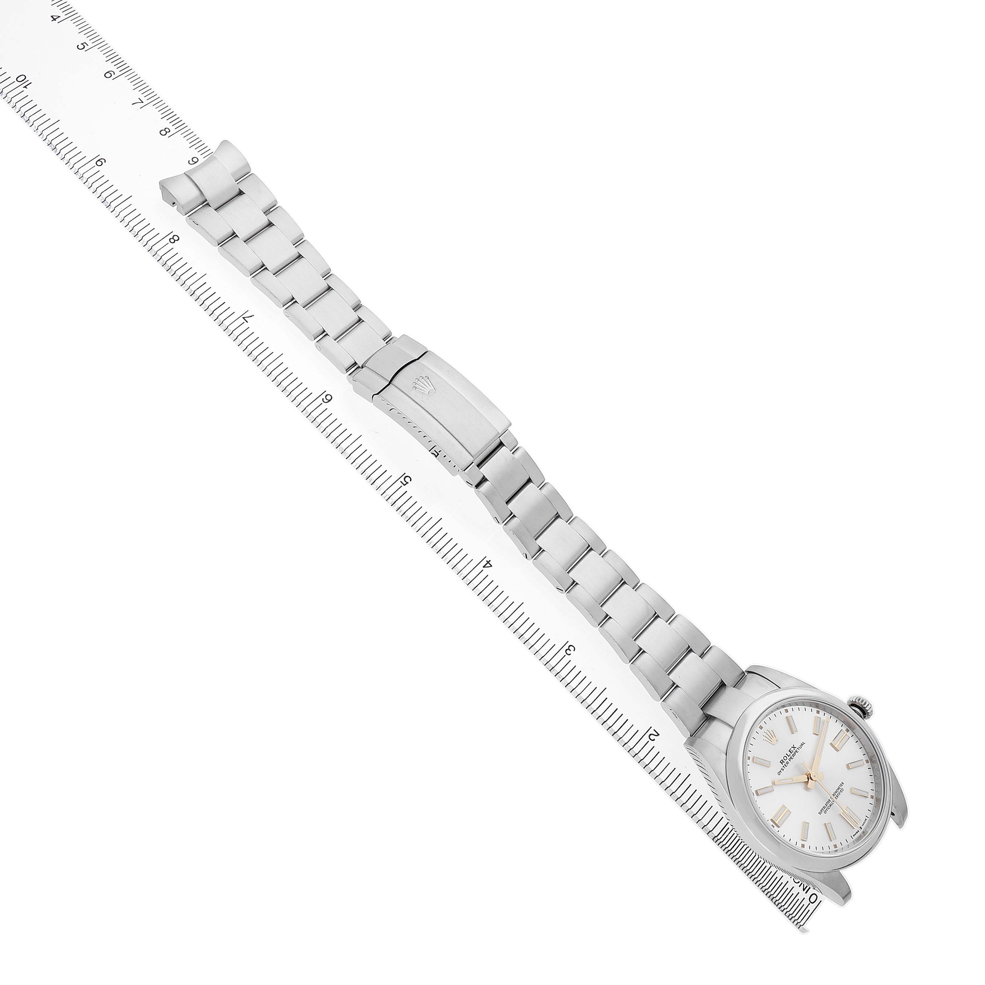 The Rolex Oyster Perpetual 124300 Men's Stainless Steel Silver Dial watch is shown at an angle displaying its full band and face, alongside a ruler for scale.