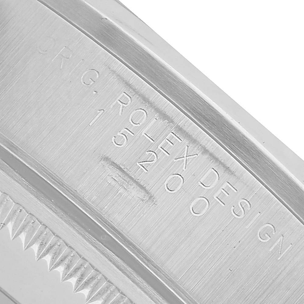 The image shows a close-up of the case details and serial engraving on a Rolex Date 15200 Men's Stainless Steel Black Dial model watch.