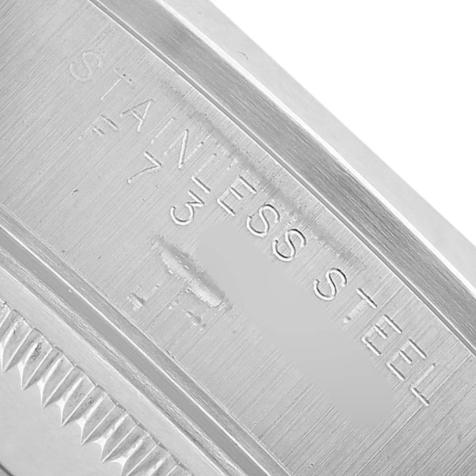 The image shows a close-up of the Rolex Date 15200 Men's Stainless Steel Black Dial model's case edge with "STAINLESS STEEL" engraving.