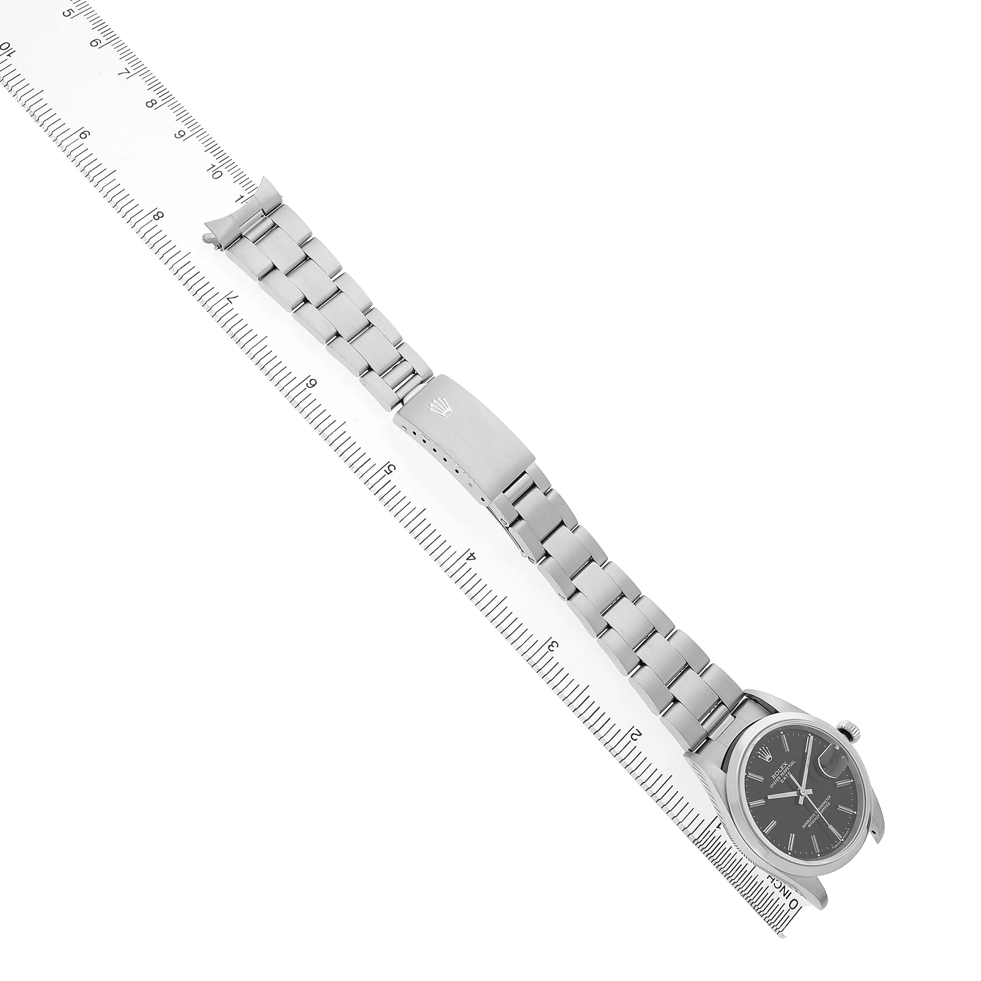 The image shows a Rolex Date 15200 Men's Stainless Steel Black Dial watch at a top-down slant, detailing the bracelet, clasp, and crown, alongside a ruler for scale.