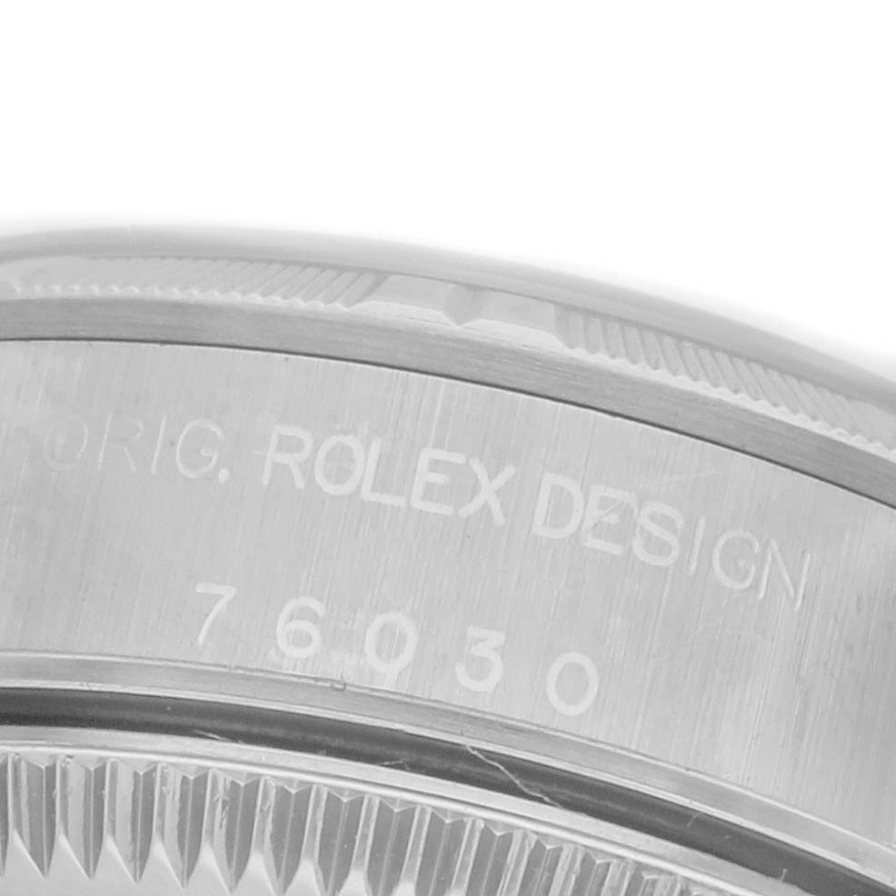 The image shows a close-up of the side of a Rolex Oyster Perpetual 76030 Women's Stainless Steel Black Dial 76030 Women's Stainless Steel Black Dial watch, highlighting the engraved model number and design details.