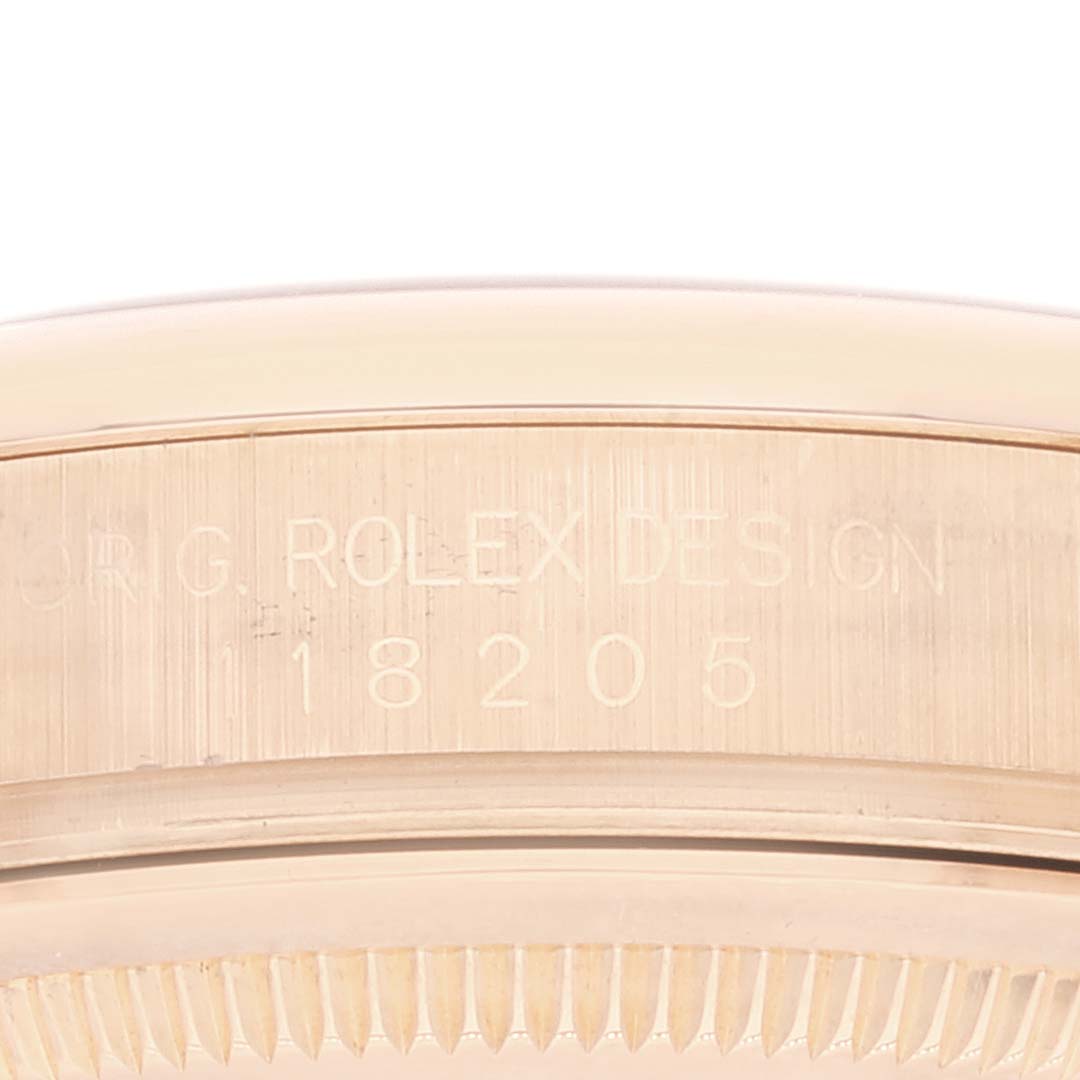 The image shows a close-up of the case edge of a Rolex President 118205 Men's Rose Gold Mother of Pearl Dial 118205 Men's Rose Gold Mother of Pearl Dial model, showcasing its smooth bezel and engraved model number "18205".