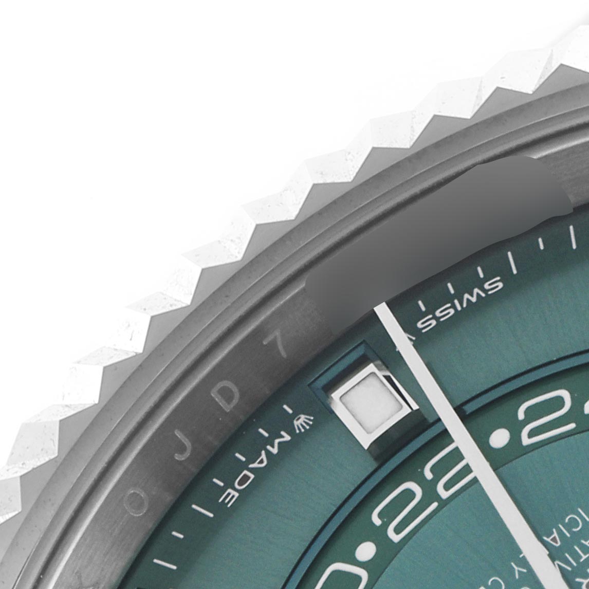 The image shows a close-up of the Rolex Sky-Dweller 336934 Men's Stainless Steel Green Dial 336934 Men's Stainless Steel Green Dial's bezel and part of the dial at an angled side view.