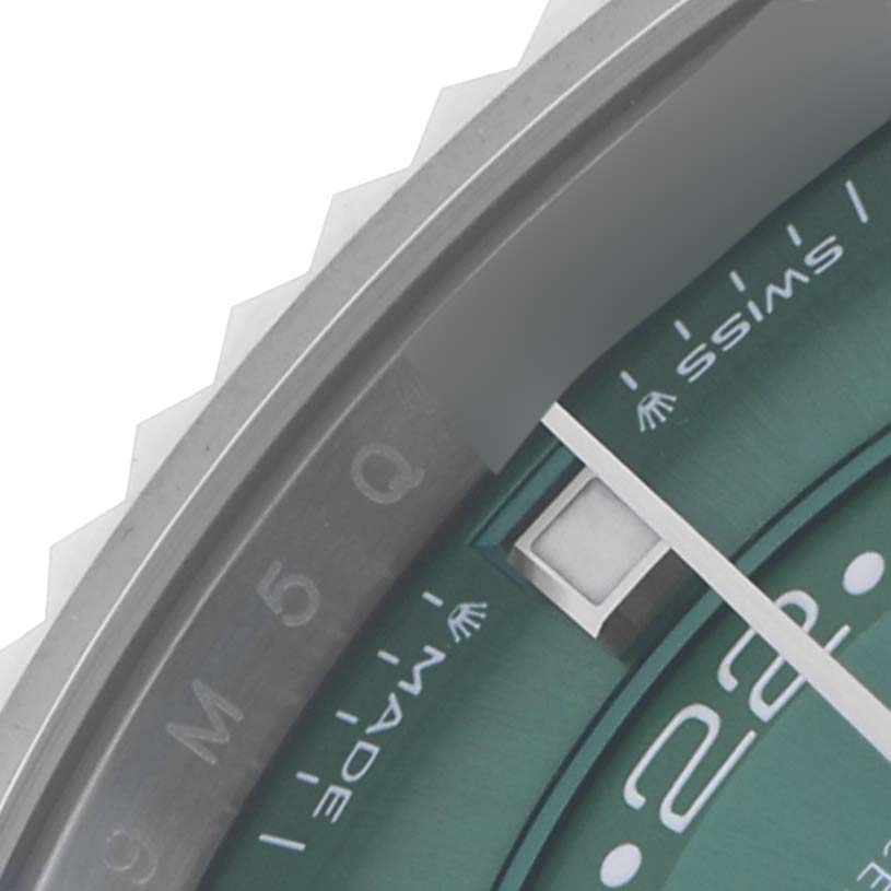 The image shows a close-up of the Rolex Sky-Dweller 336934 Men's Stainless Steel Green Dial 336934 Men's Stainless Steel Green Dial's watch face, highlighting the bezel, part of the dial, and the date window.