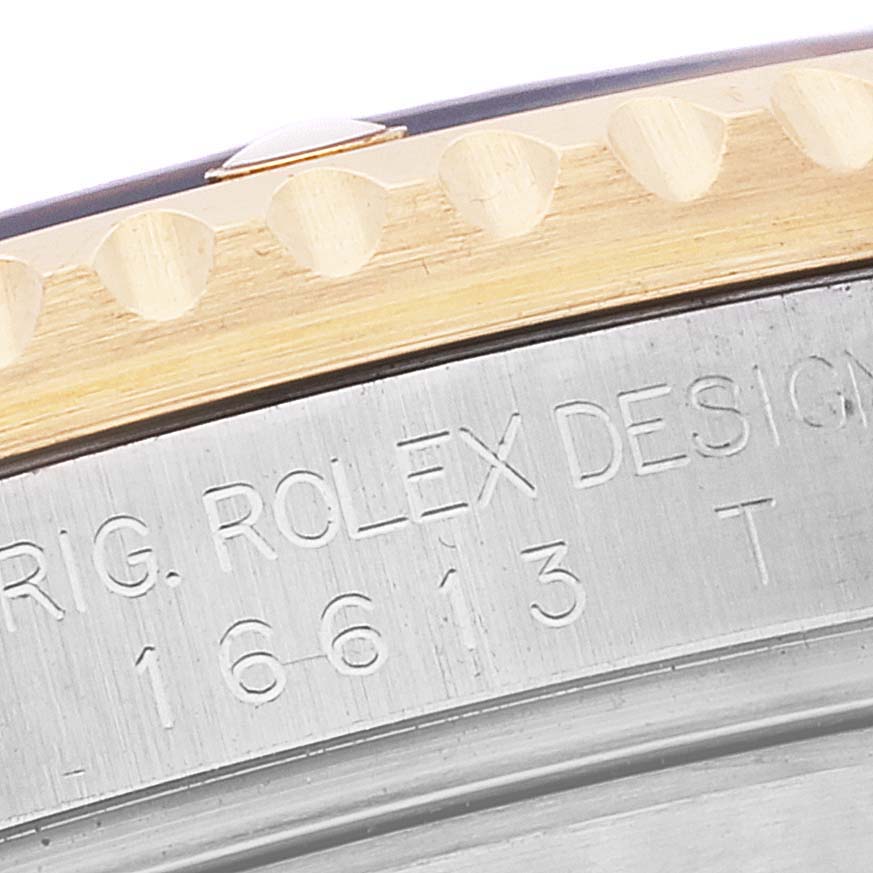 This close-up image shows the bezel and engraved case side of a Rolex Submariner 16613 Men's Steel and Gold (two tone) Blue Dial 16613 Men's Steel and Gold (two tone) Blue Dial watch.