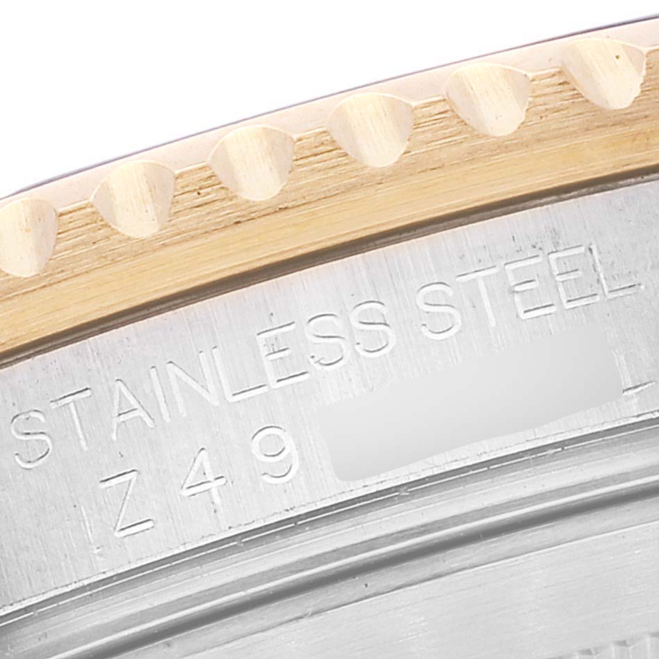 The image shows a close-up angle of the bezel and the engraved stainless steel case of a Rolex Submariner 16613 Men's Steel and Gold (two tone) Blue Dial 16613 Men's Steel and Gold (two tone) Blue Dial watch.