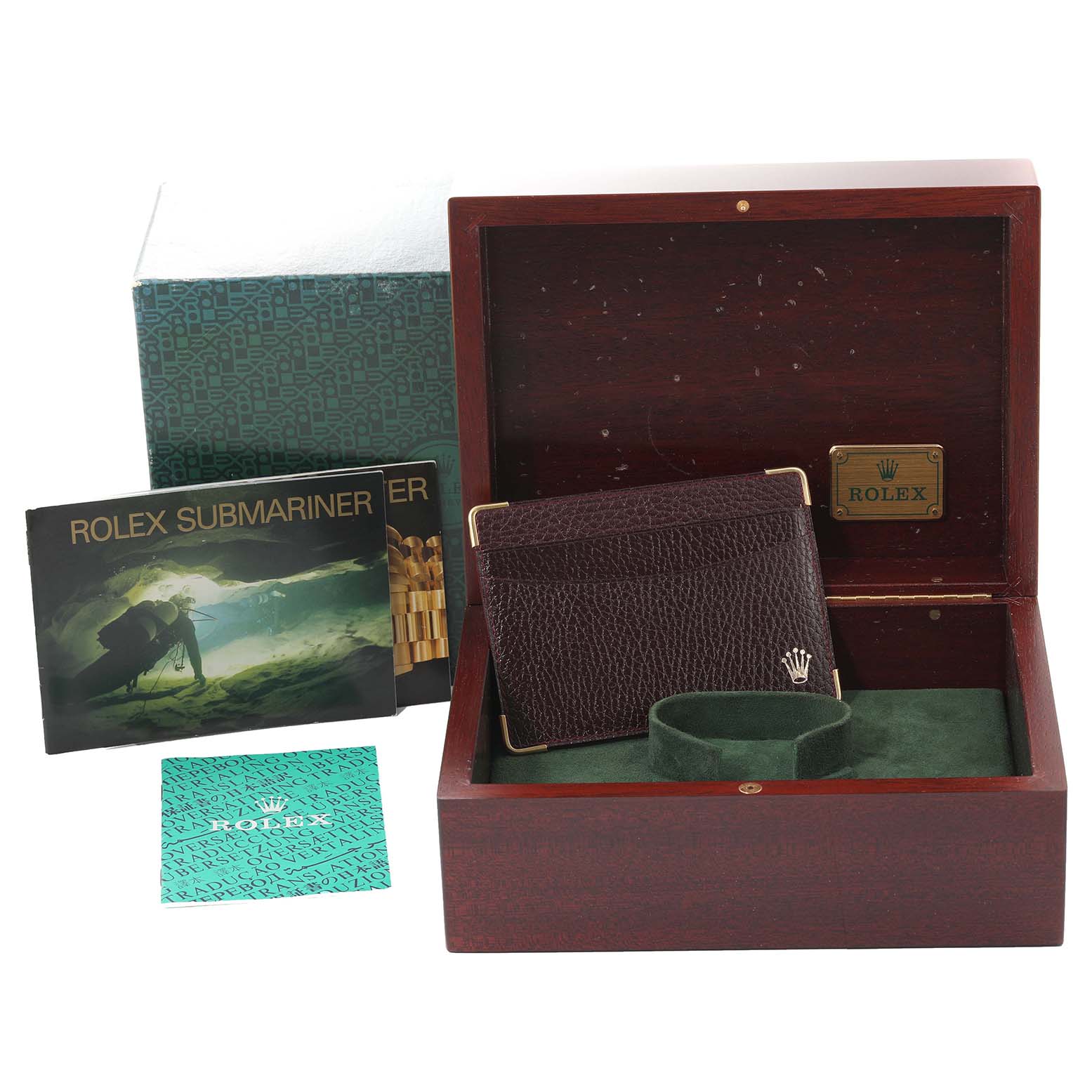 This image shows an open Rolex Submariner 16618 Men's Yellow Gold Blue Dial 16618 Men's Yellow Gold Blue Dial box, accompanying manuals, and a brown leather pouch.