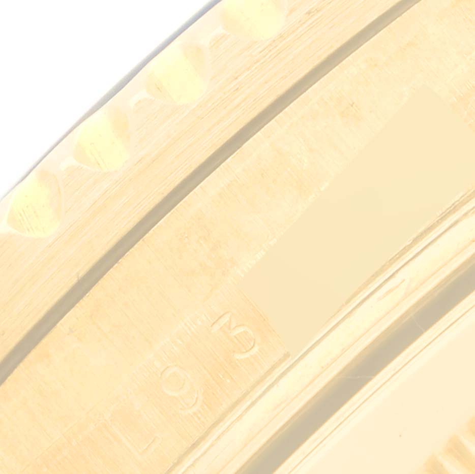This close-up image shows a partial view of the bezel and case of a Rolex Submariner 16618 Men's Yellow Gold Blue Dial 16618 Men's Yellow Gold Blue Dial watch.