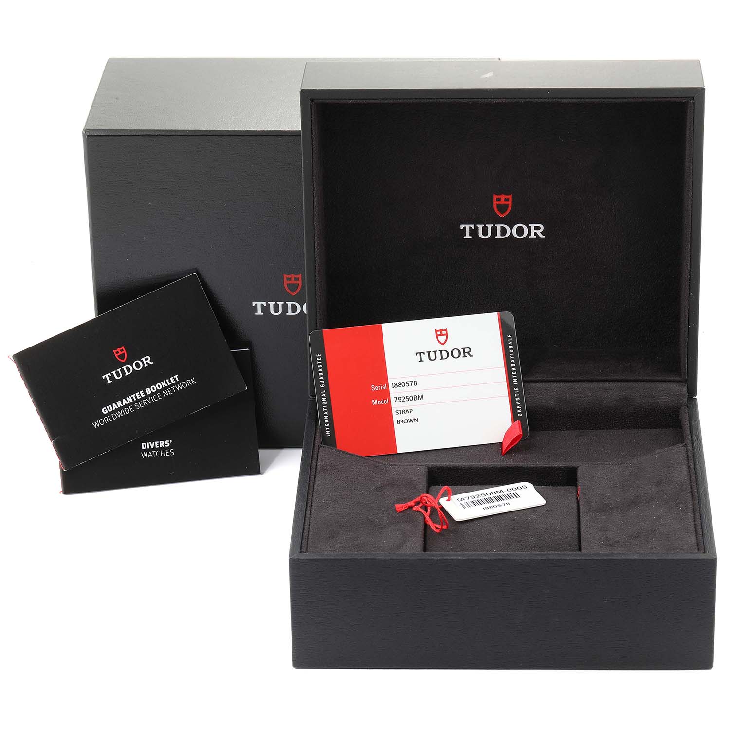 The image shows an open Tudor Heritage Black Bay 79250B Men
s Bronze Brown Dial 79250B Men
s Bronze Brown Dial watch box with documents and tags displayed around it.