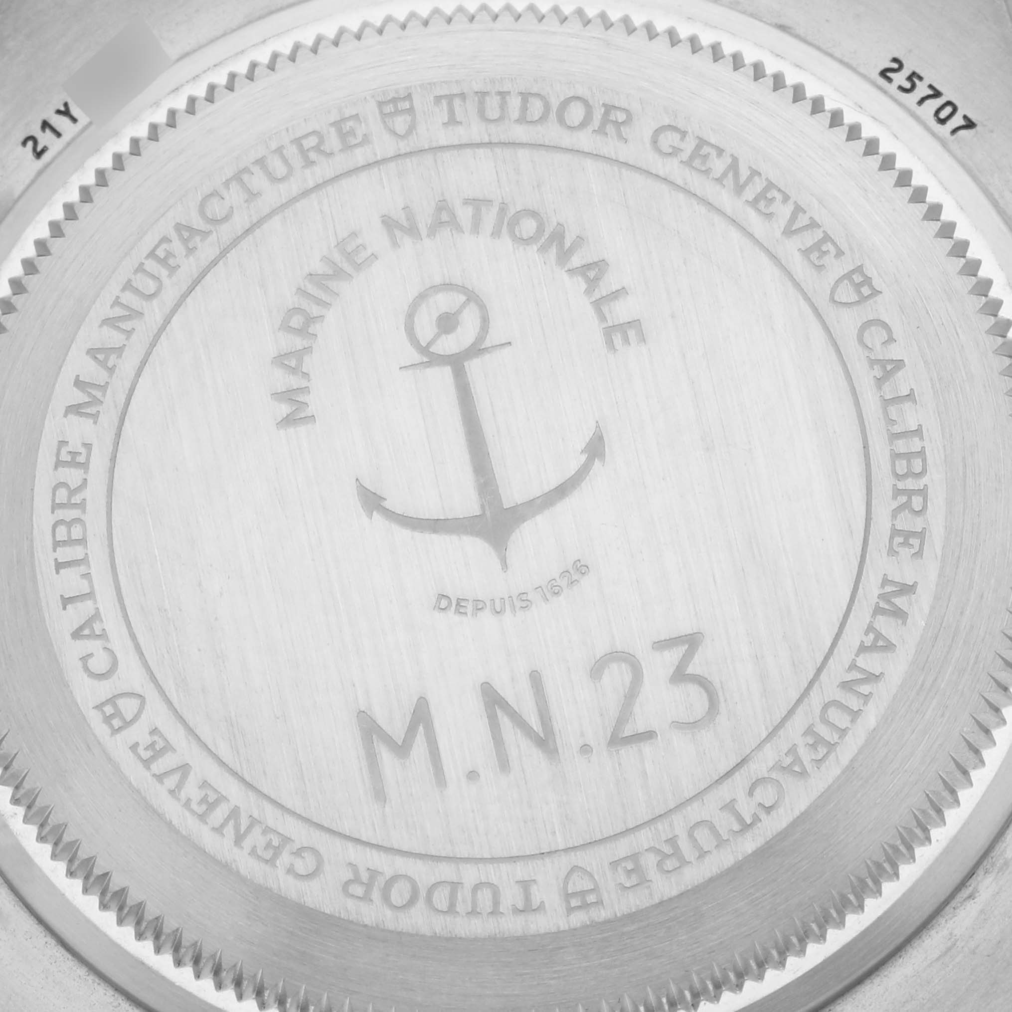 The image shows the engraved case back of the Tudor Pelagos 25707B Men's Titanium Blue Dial 25707B Men's Titanium Blue Dial watch, featuring inscriptions and an anchor motif.